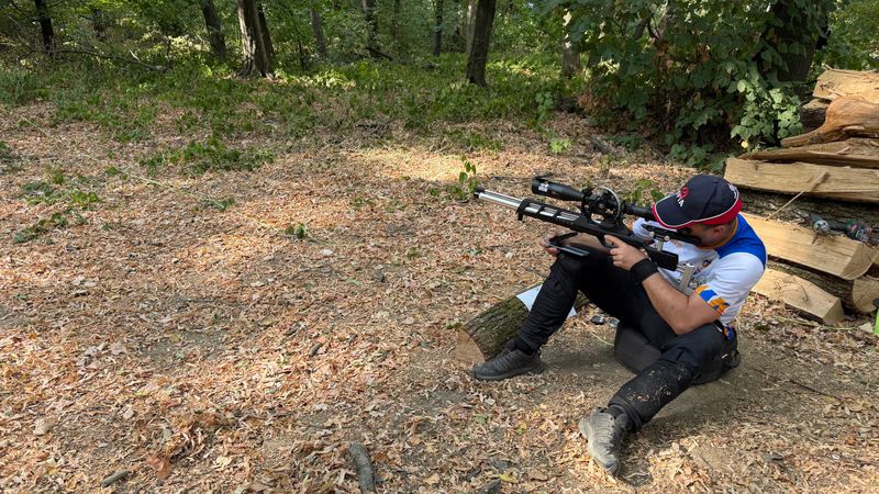 Takmičar u klasičnom Field Target sedećem položaju nišani uzbrdo