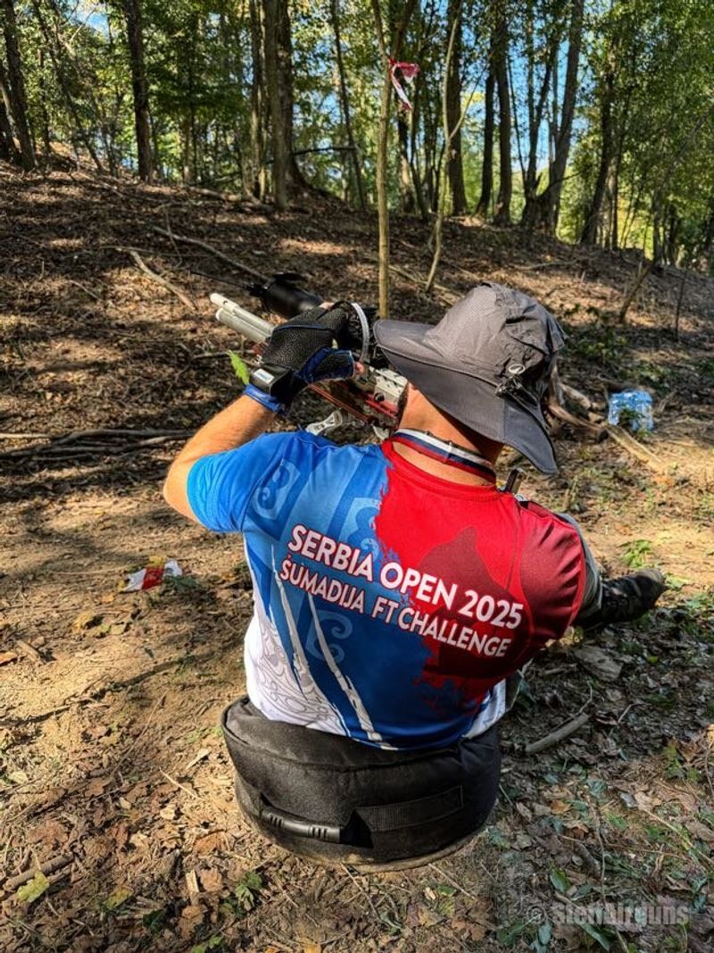 Takmičar u dresu Serbia Open 2025 nišani, pogled s leđa