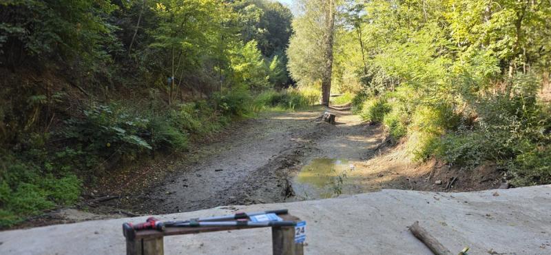 Stajalište na betonskom platou iznad potoka, sa klupom i puškom
