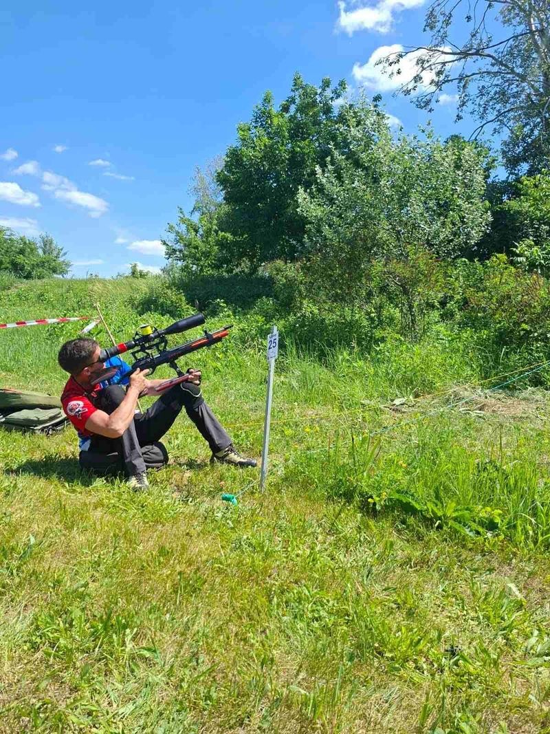 Takmičar gađa uzbrdo prema meti u žbunju