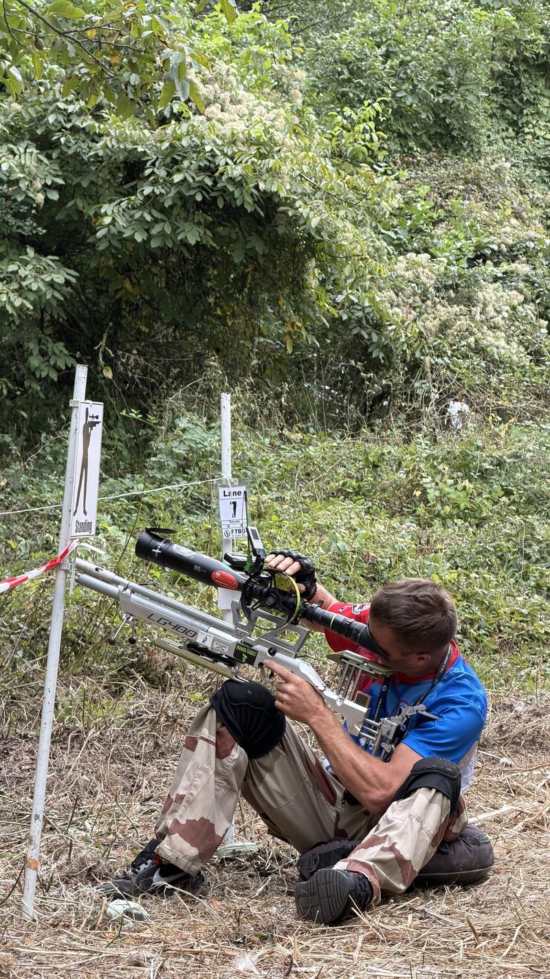 Strelac nišani kroz optiku u sedećem stavu