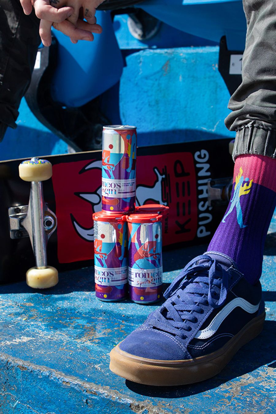Romeo's Gin Spritz cans on a skateboard, Robin des bas x MEKA Keep Pushing socks on the feet — the whole world in one frame