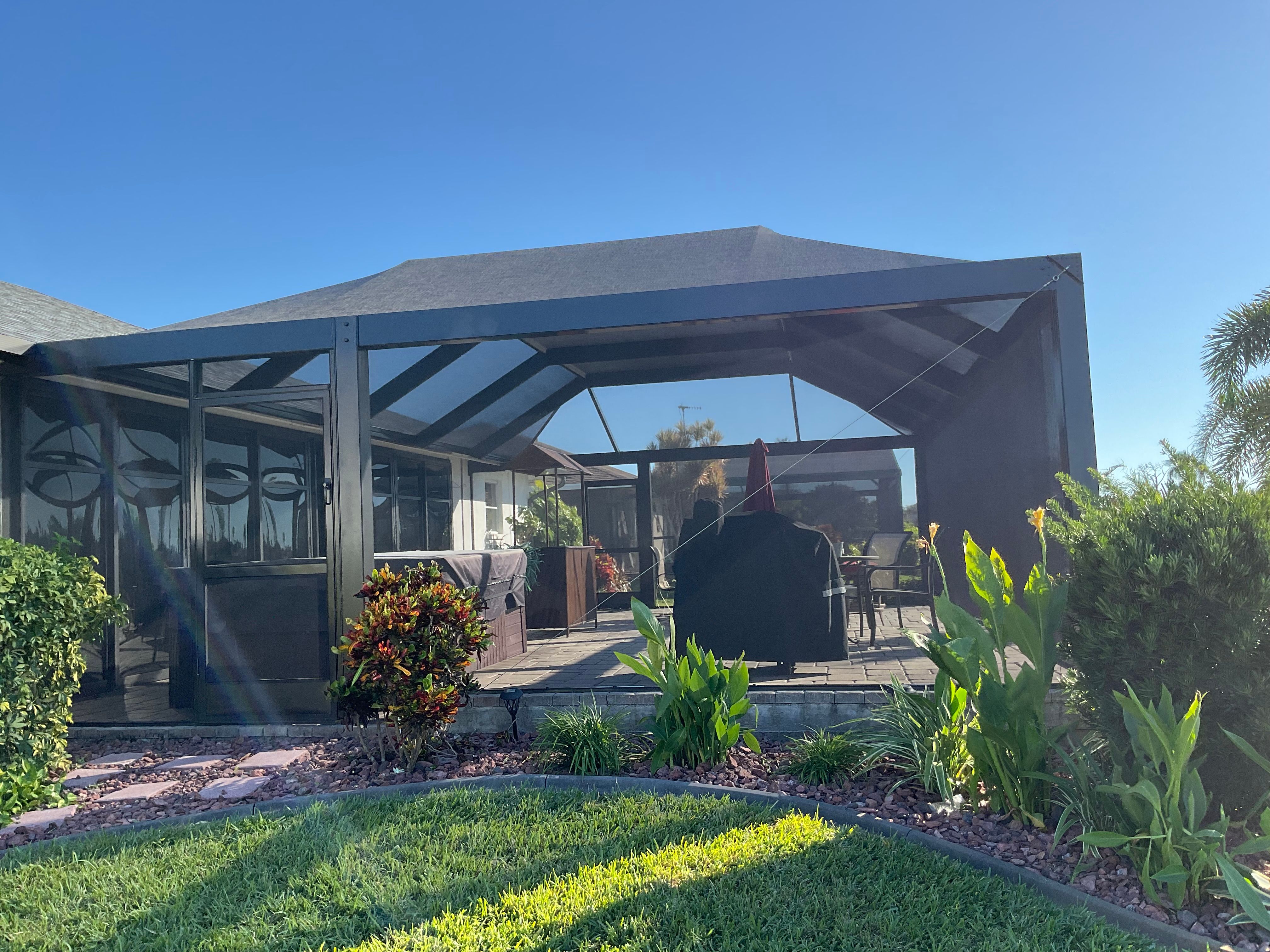 Dark bronze aluminum pool screen enclosure with gable roof, pool and paver deck, South Florida residential backyard — AB Aluminum & Screens