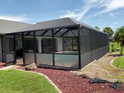 Hip-style pool screen enclosure in a South Florida backyard