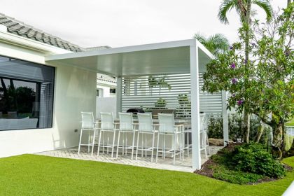 White aluminum open-lattice pergola attached to South Florida residential home, tropical backyard with palm trees and lush garden landscaping — AB Aluminum & Screens
