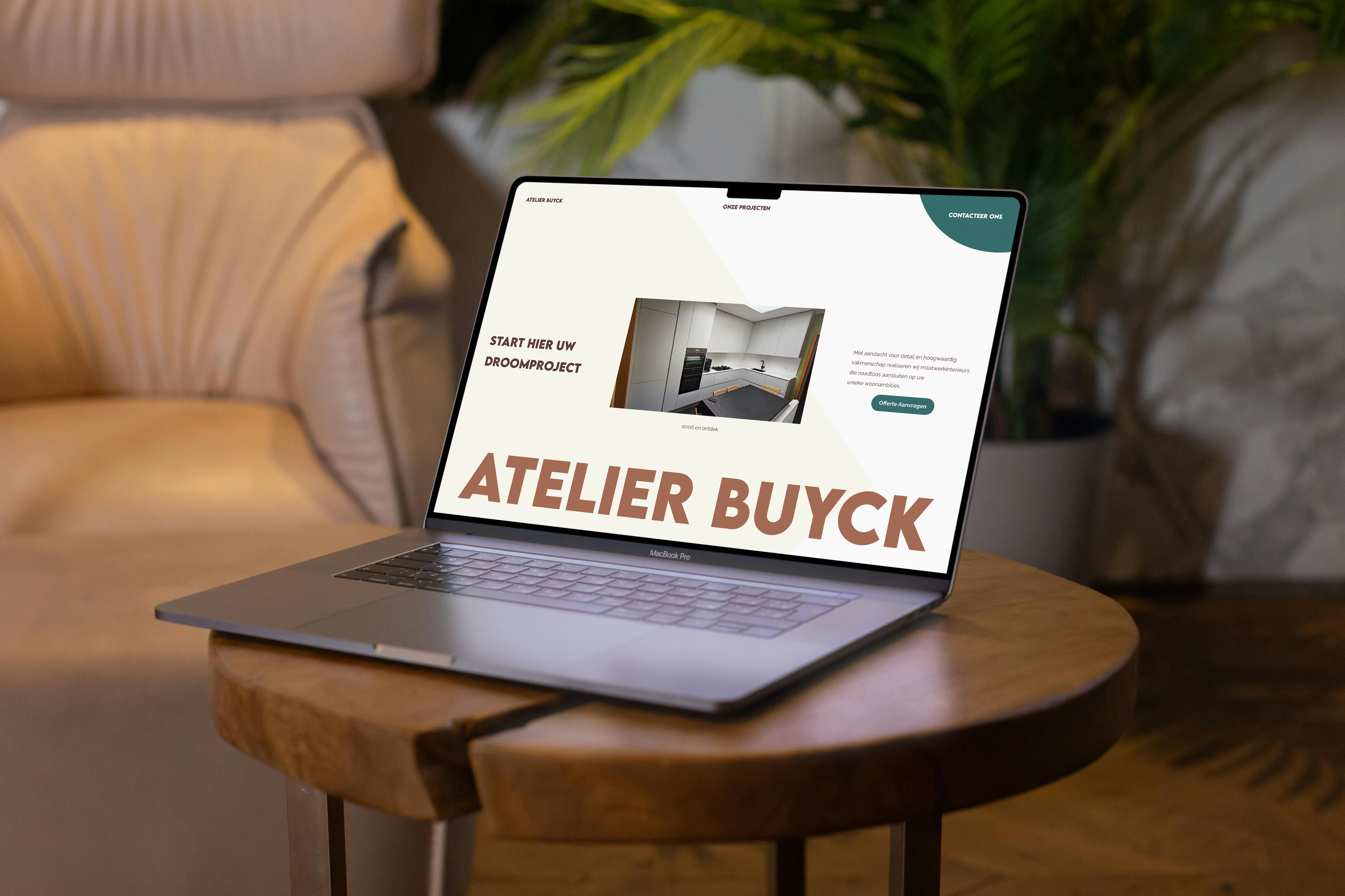 Een Laptop in een living, een zetel en een kamerplant in de achtergrond. De laptop staat op een tafeltje met een metalen onderstel. De laptop toont de website van atelier buyck: https://atelierbuyck.be