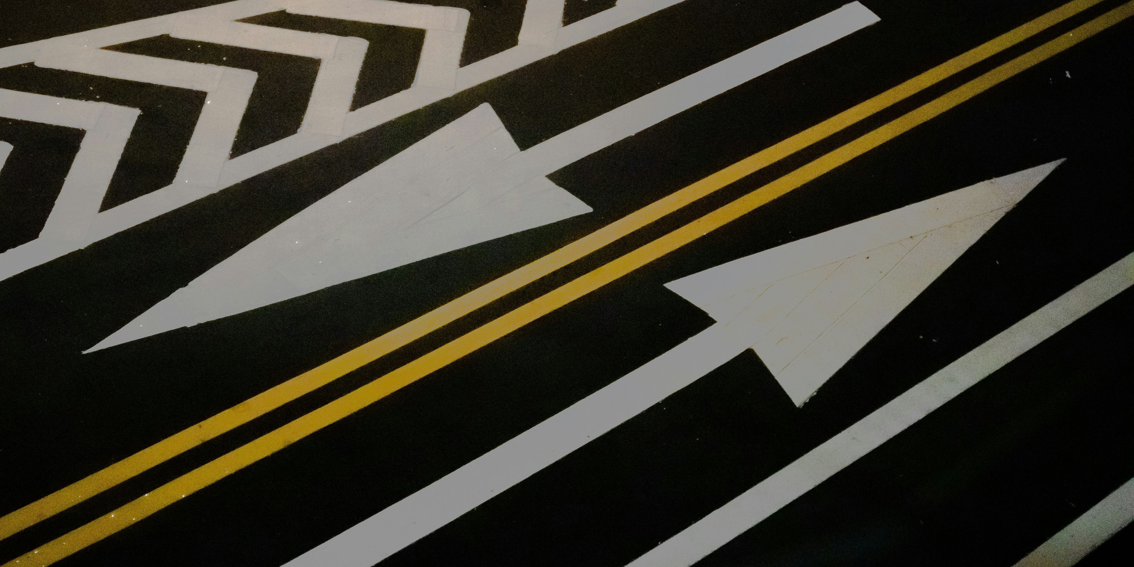 a close up of a road with arrows painted on it .