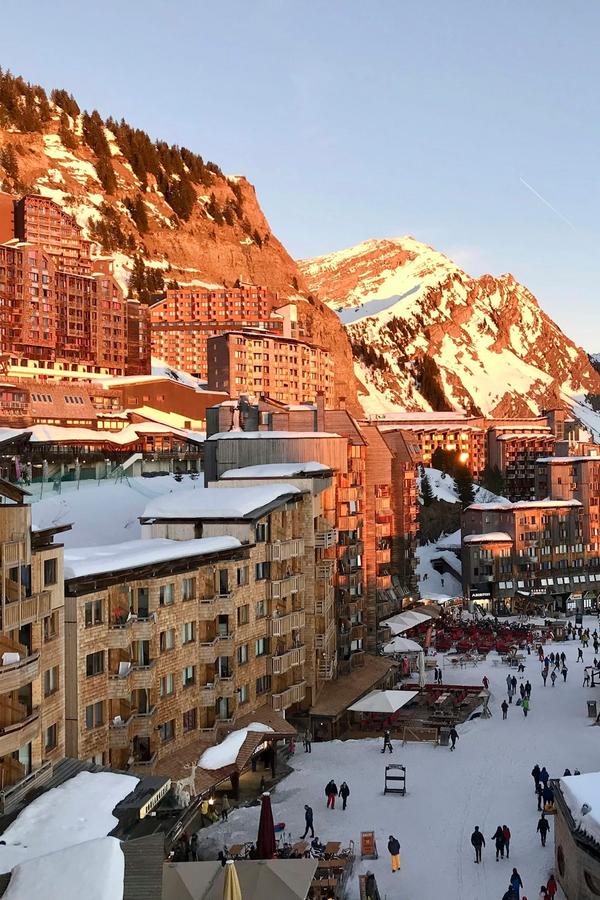 Avoriaz's wood-clad buildings glowing at sunset above the snowy village