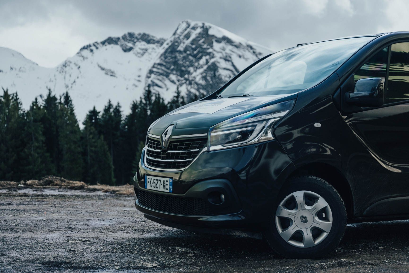 Morzine Bus Renault Trafic minibus parked in front of snowy Alpine peaks