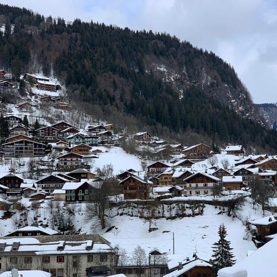 Morzine's chalets under snow, with the valley and forested mountains behind
