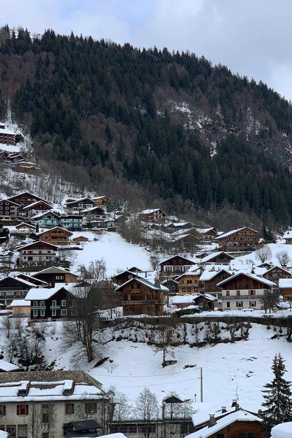 Morzine's chalets under snow, with the valley and forested mountains behind