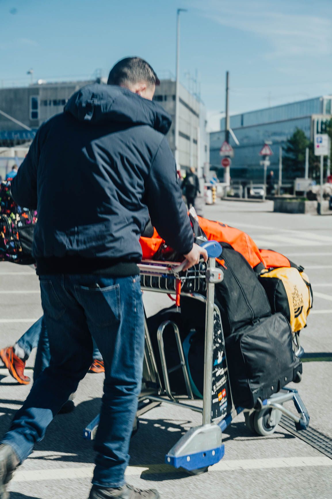 Morzine Bus driver pushing a luggage trolley with ski bags at Geneva Airport