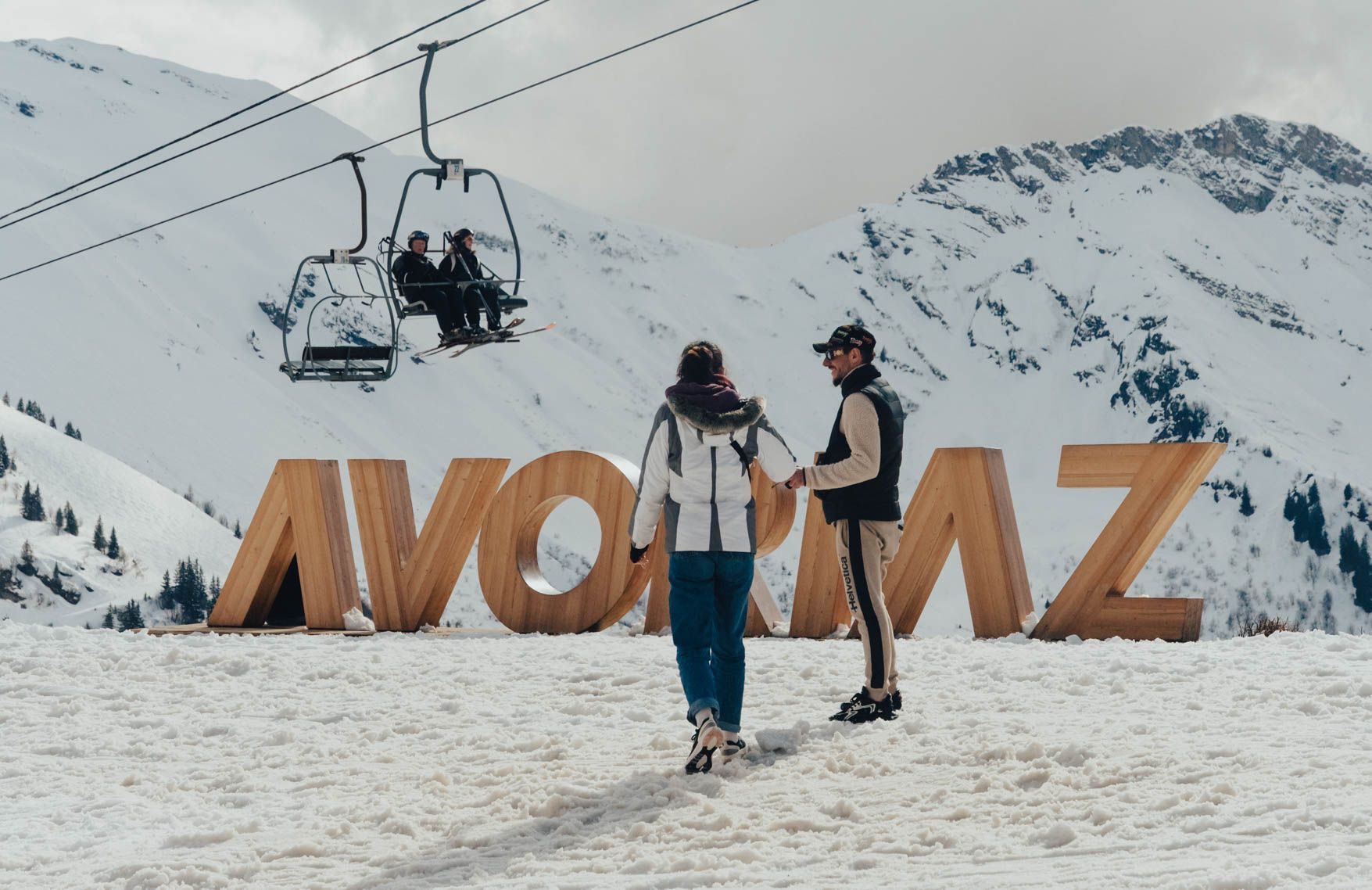 Skiers by the giant Avoriaz letters with a chairlift behind