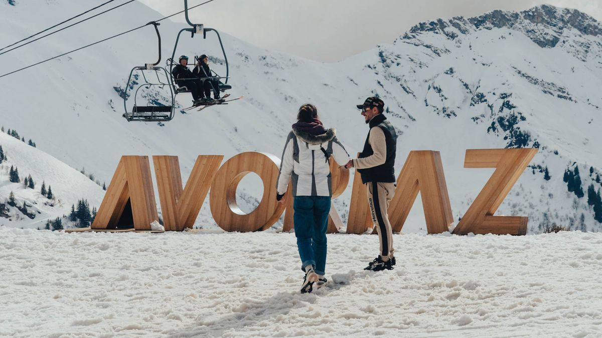 Skiers by the giant Avoriaz letters with a chairlift behind