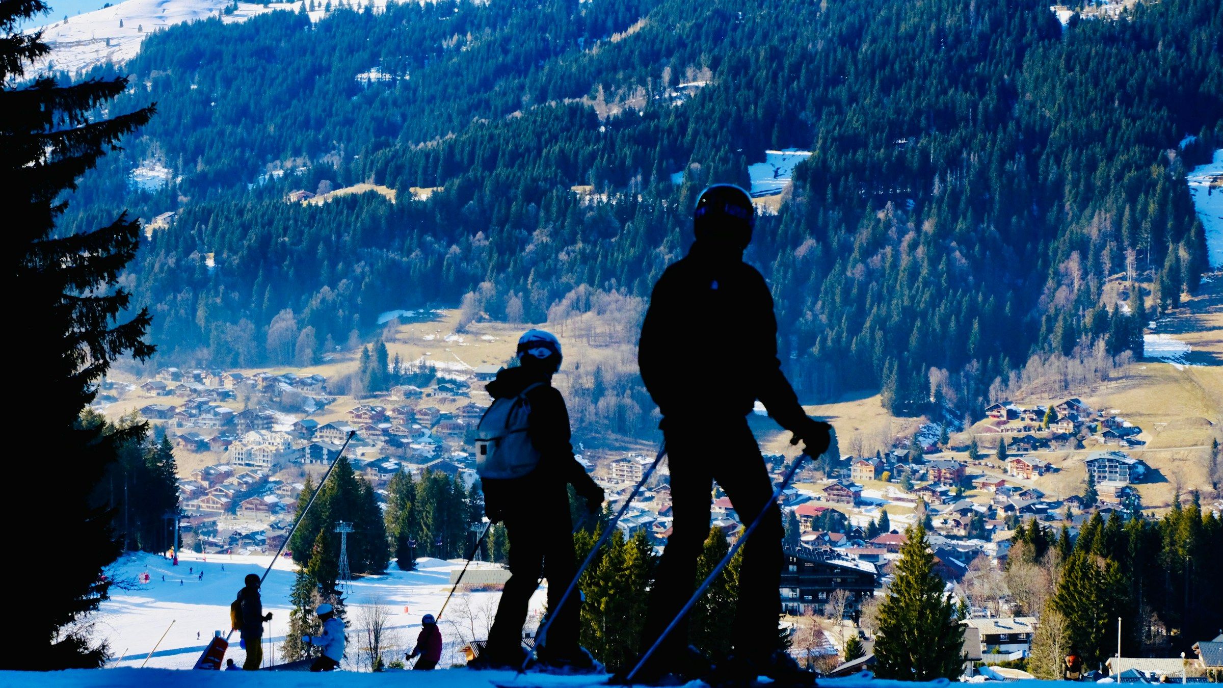 Two skiers on the slopes above Les Gets village