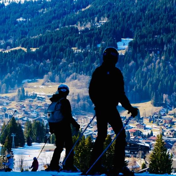 Two skiers on the slopes above Les Gets village