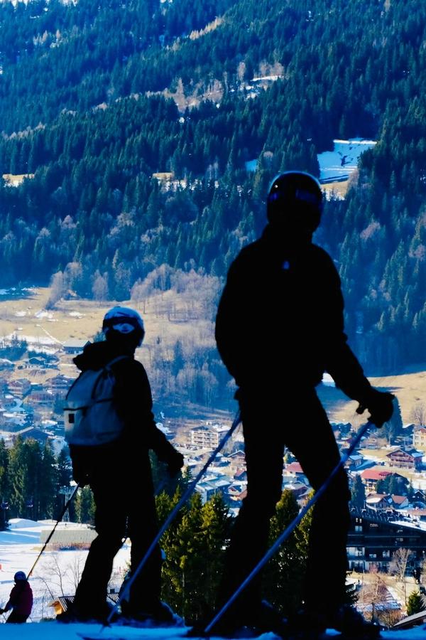 Two skiers on the slopes above Les Gets village