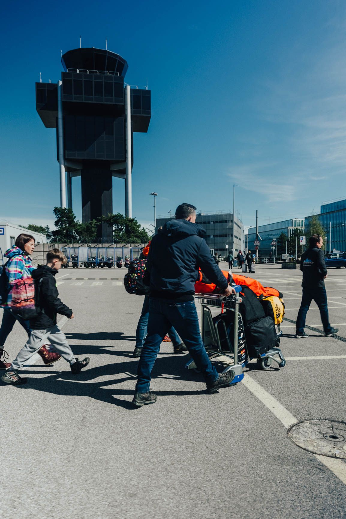 A family with ski bags walking to their transfer at Geneva Airport
