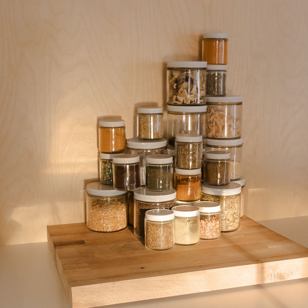 food in jars stacked and laid out on a cutting board