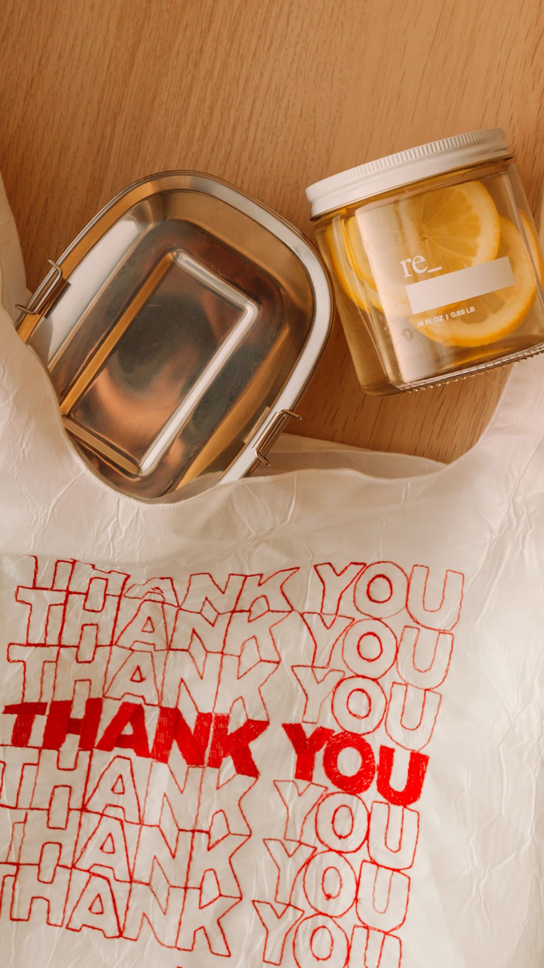 stainless steel and glass food containers placed beside a reusable recycled plastic tote bag