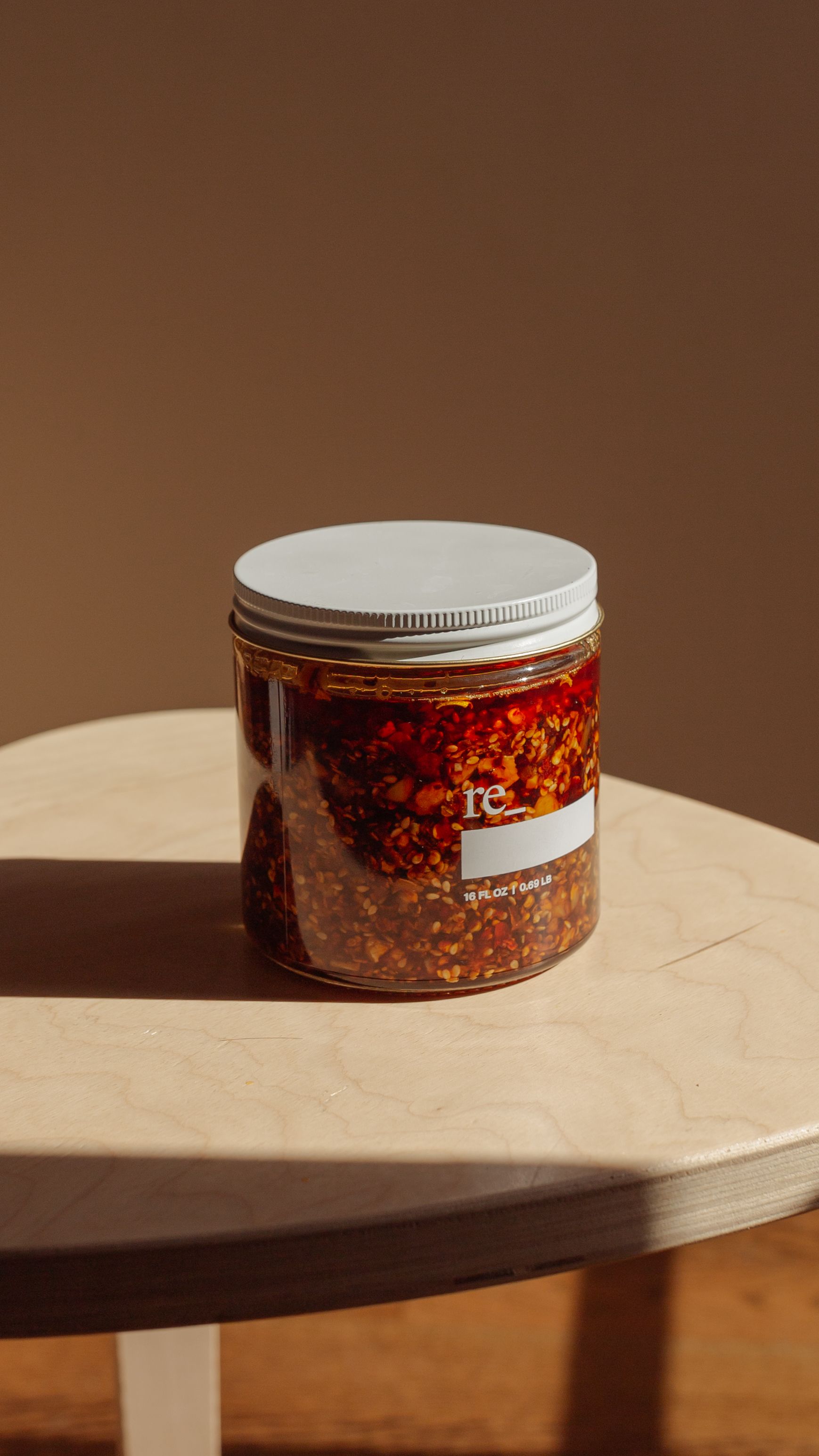 chili crisp in oil on a tabletop with golden hour sunlight