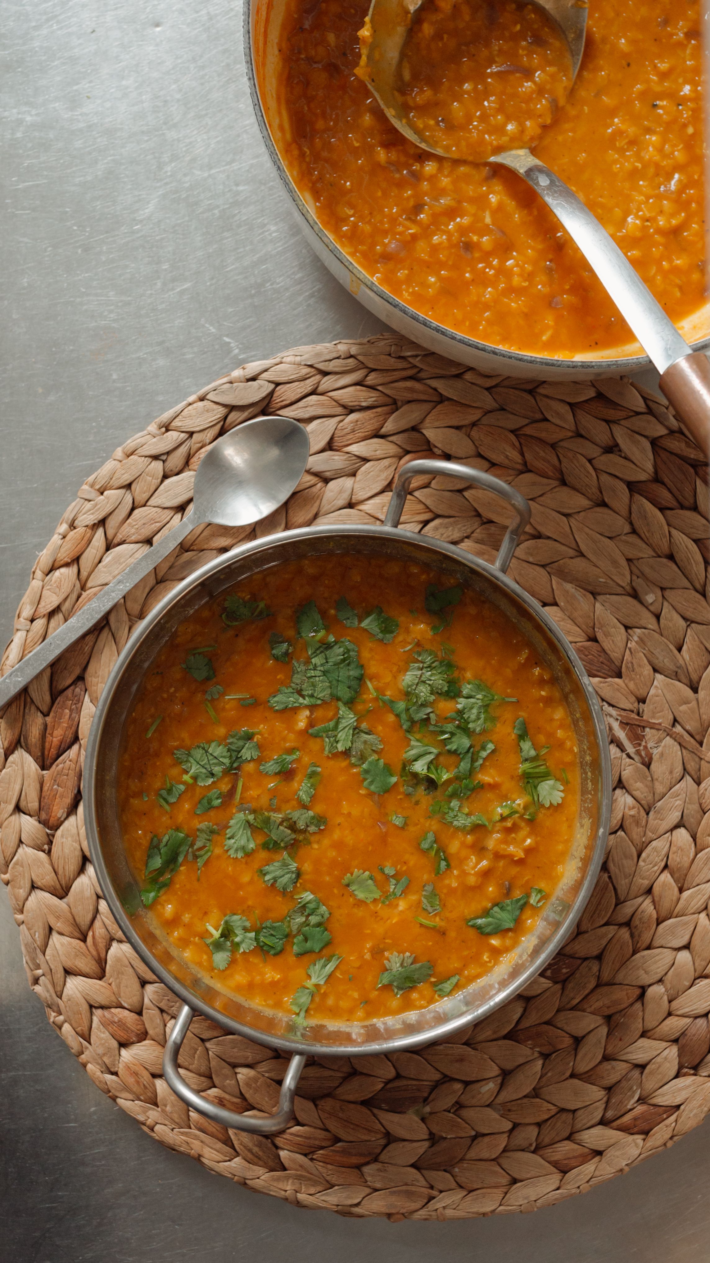 lentil dahl in a bronze bowl on a rattan placemat
