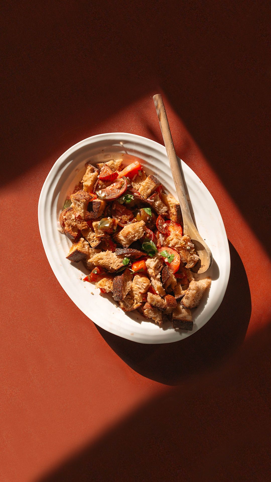 old bub and grandmas bread used for a panzanella salad in a bowl on a red placemat