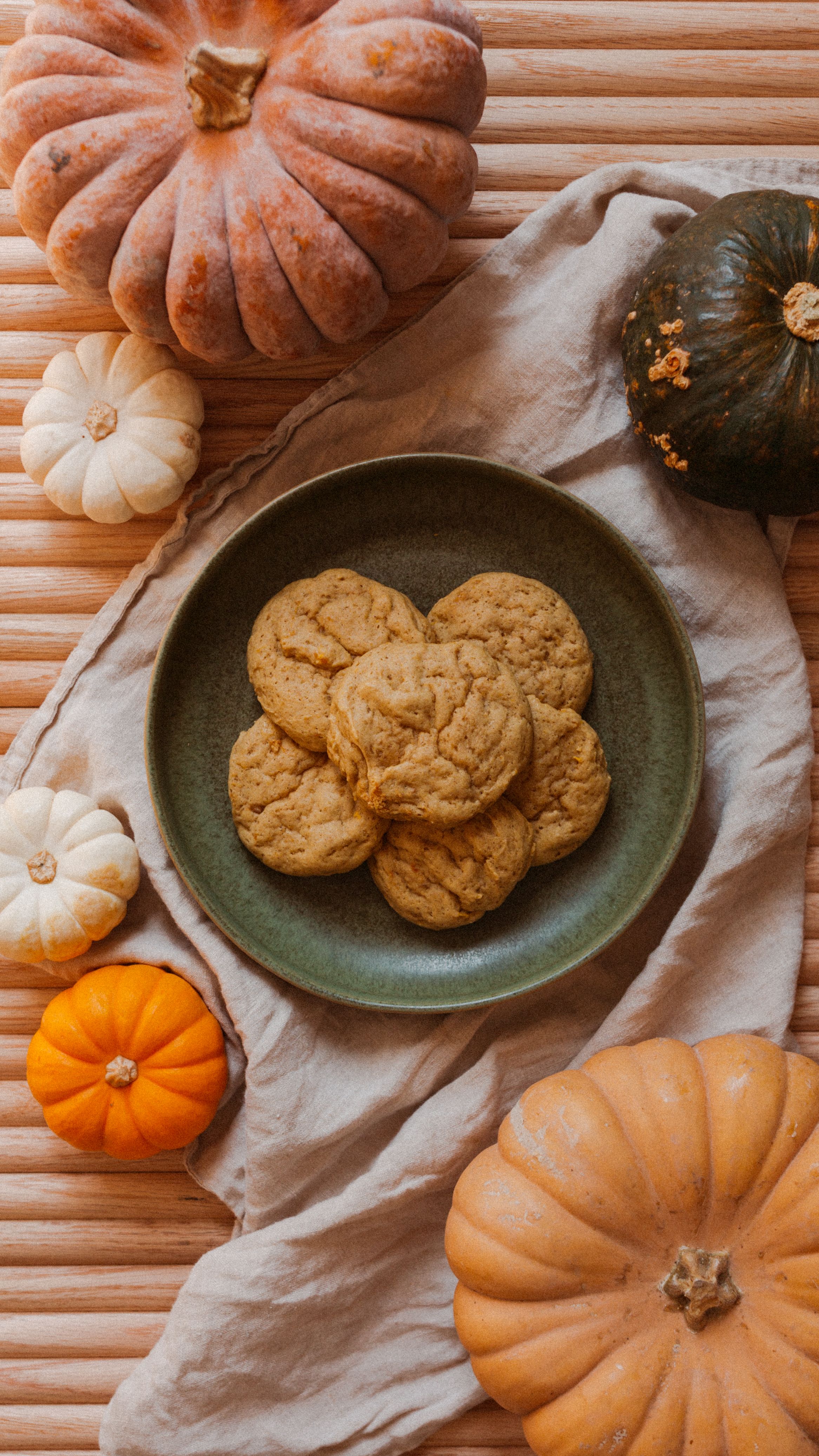pumpkin cookies on a tambour table surrounded by gourds