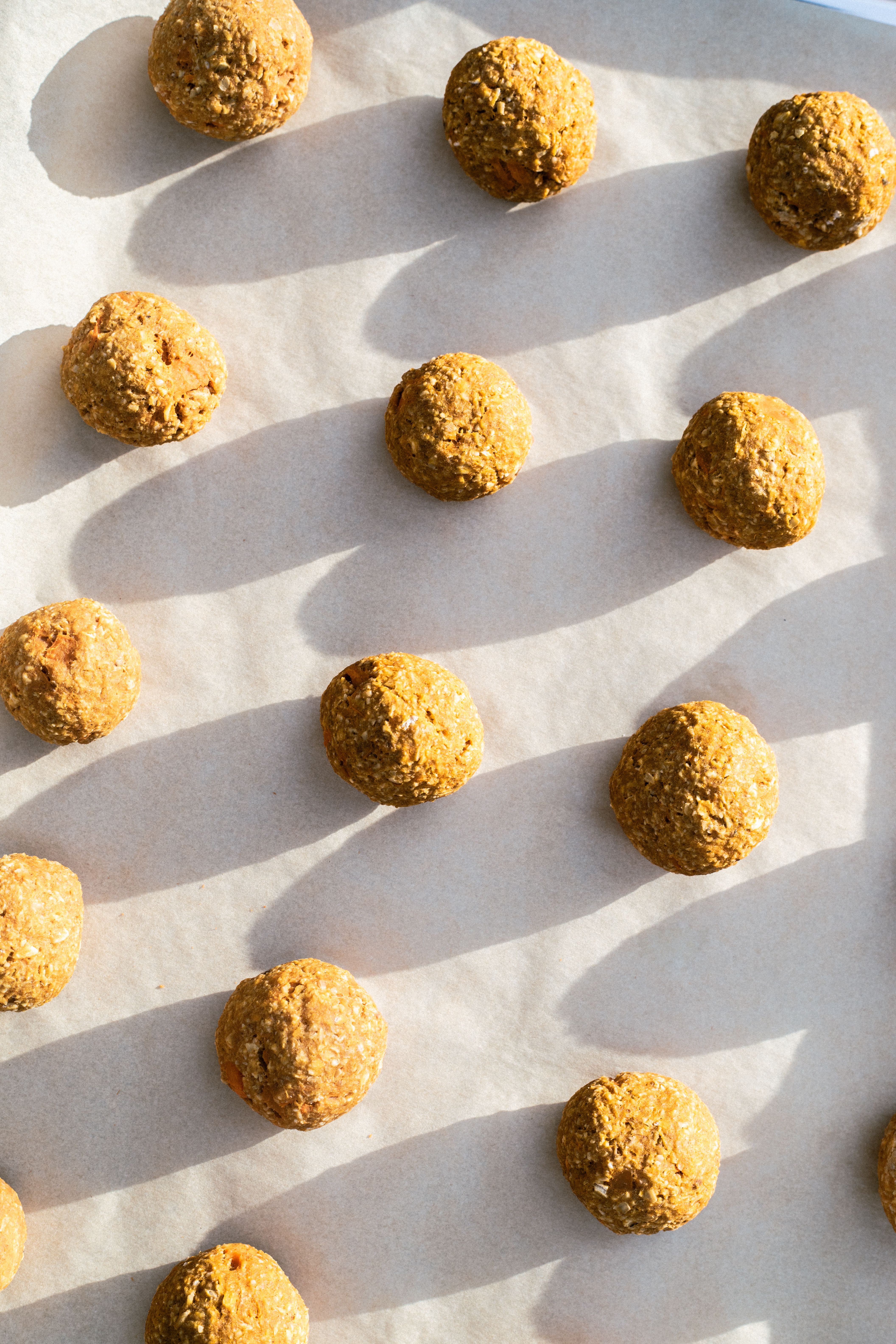 homemade dog treats rolled up in balls on a baking sheet