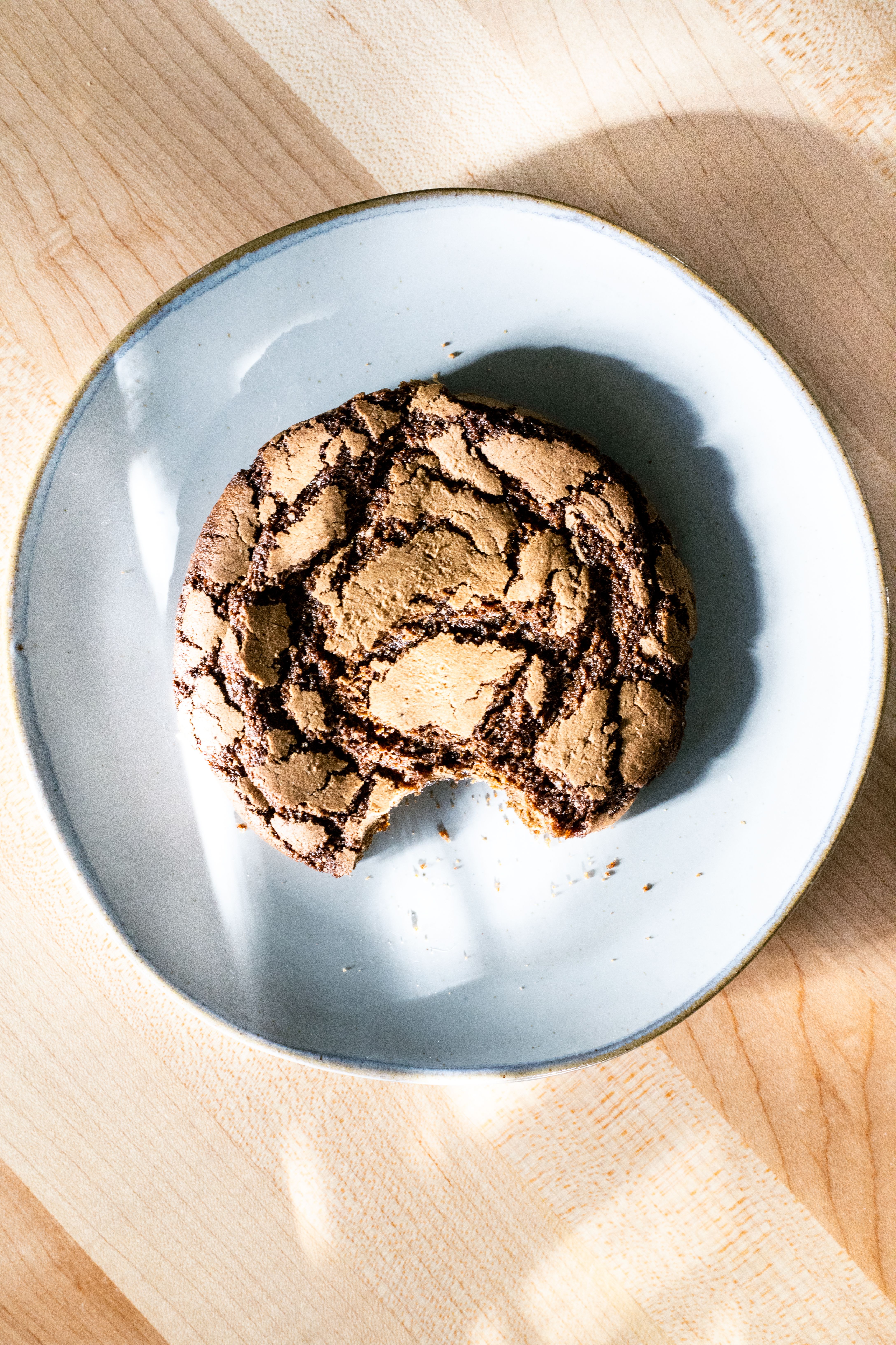 one bite eaten from a gingerbread cookie on a ceramic plate