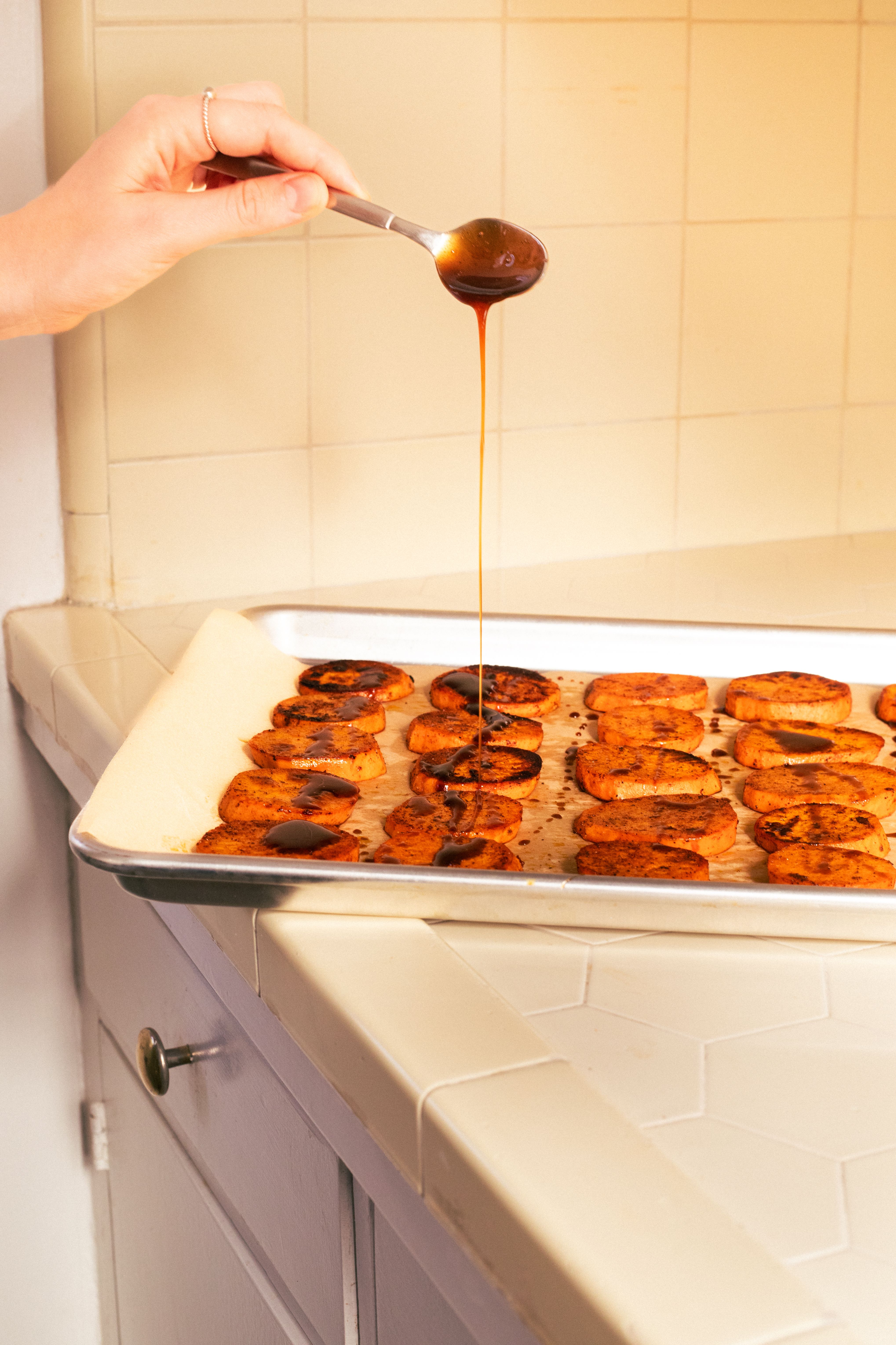 balsamic glazed sweet potatoes on kitchen counter with tile backdrop