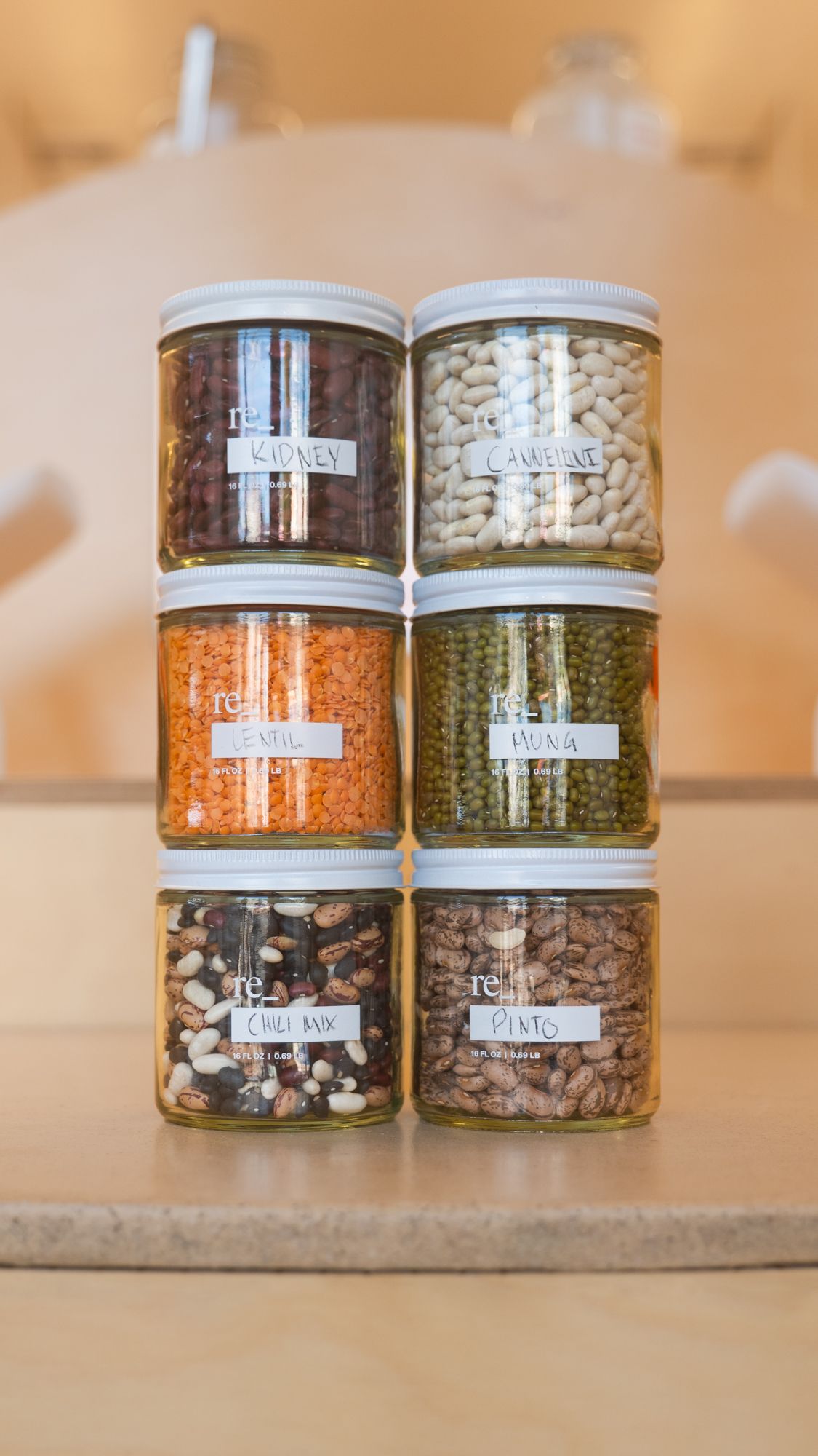 six jars of organic beans stacked on a counter at re_ grocery