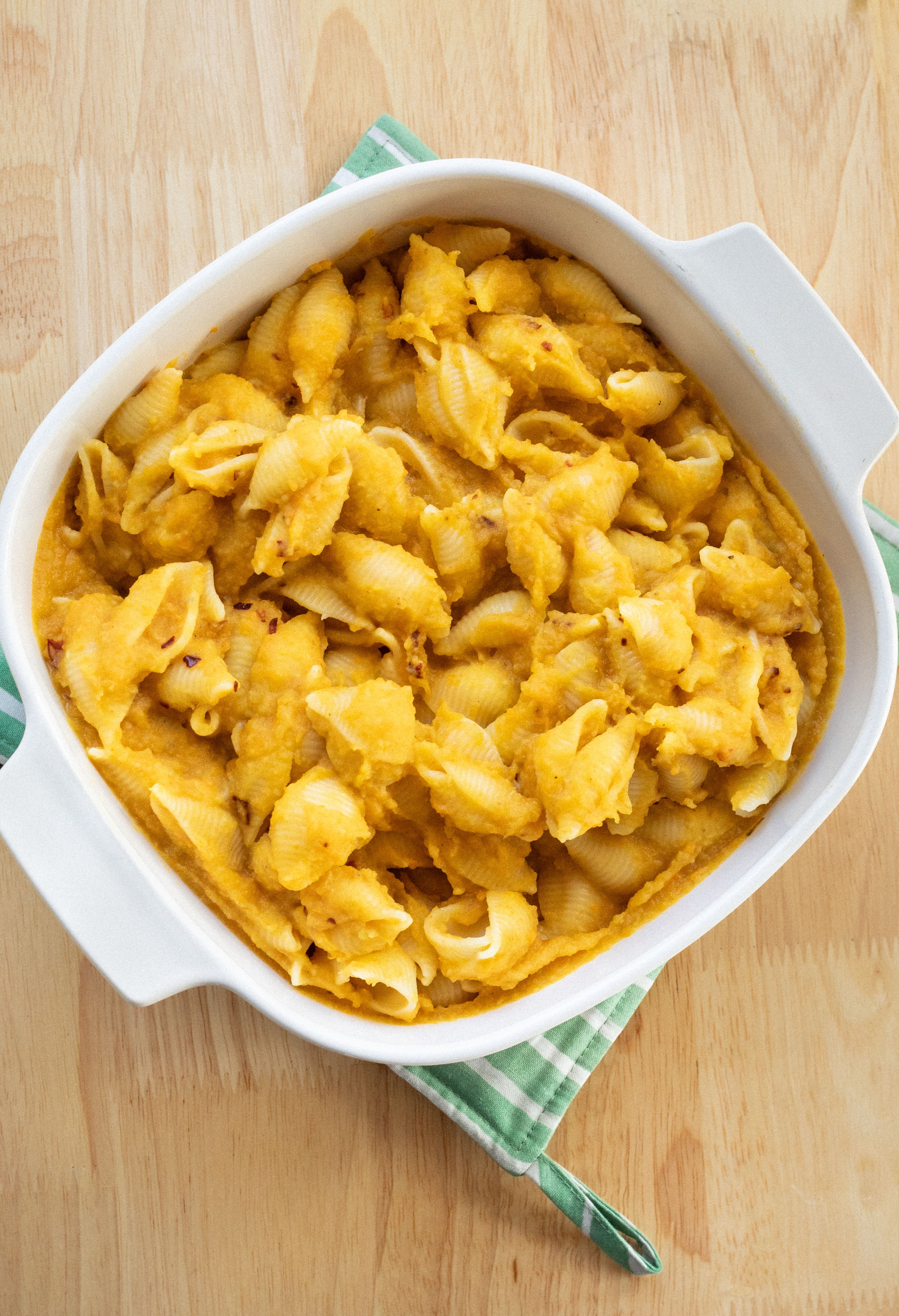 pumpkin cream mac and cheese in a baking dish on a wooden table