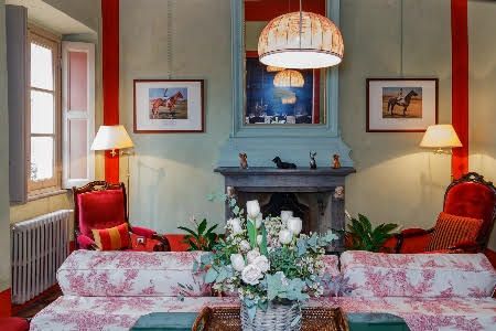 living room with cauch, lamps, paintings and flowers