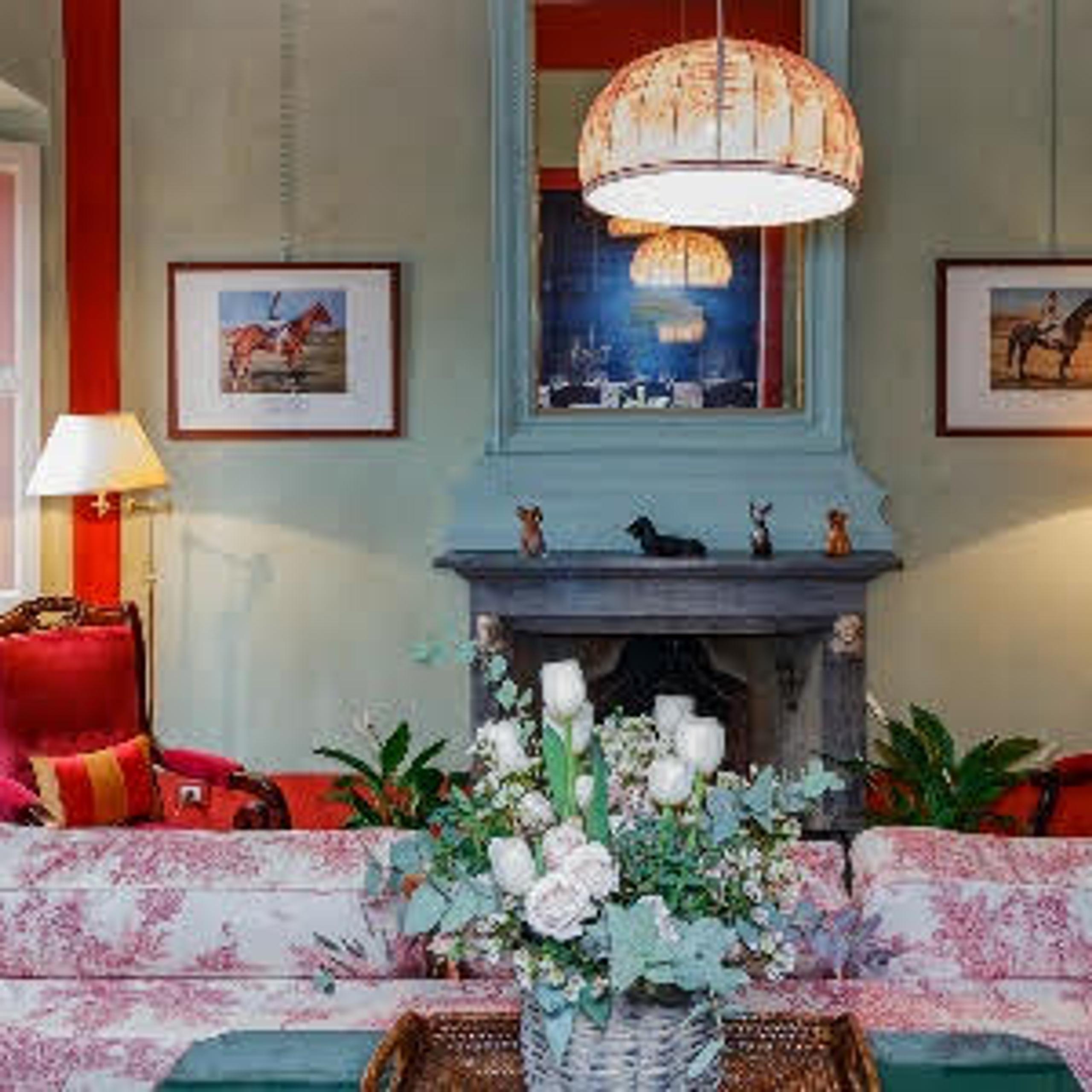 living room with cauch, lamps, paintings and flowers