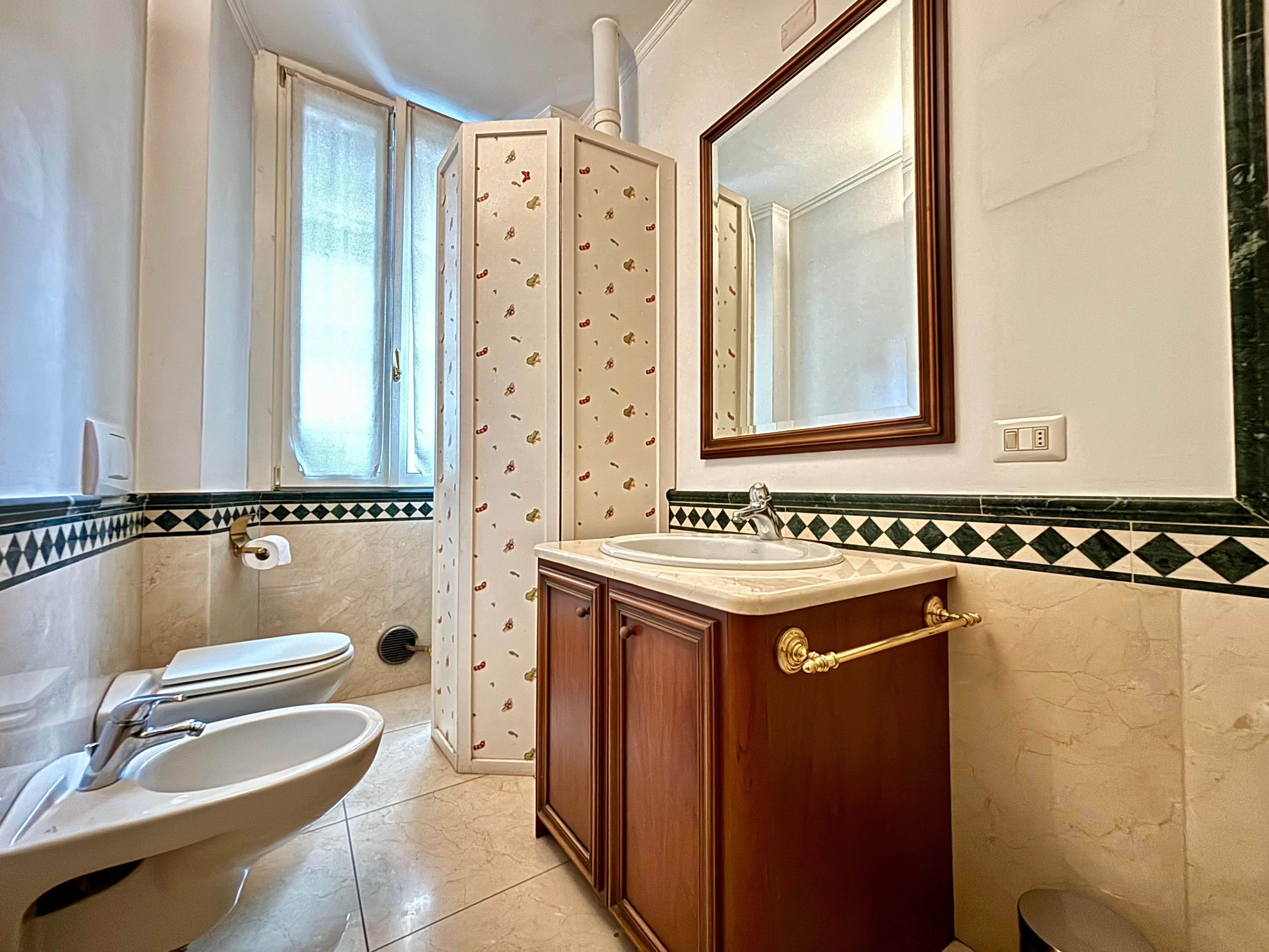 bathroom with window, mirror, sink