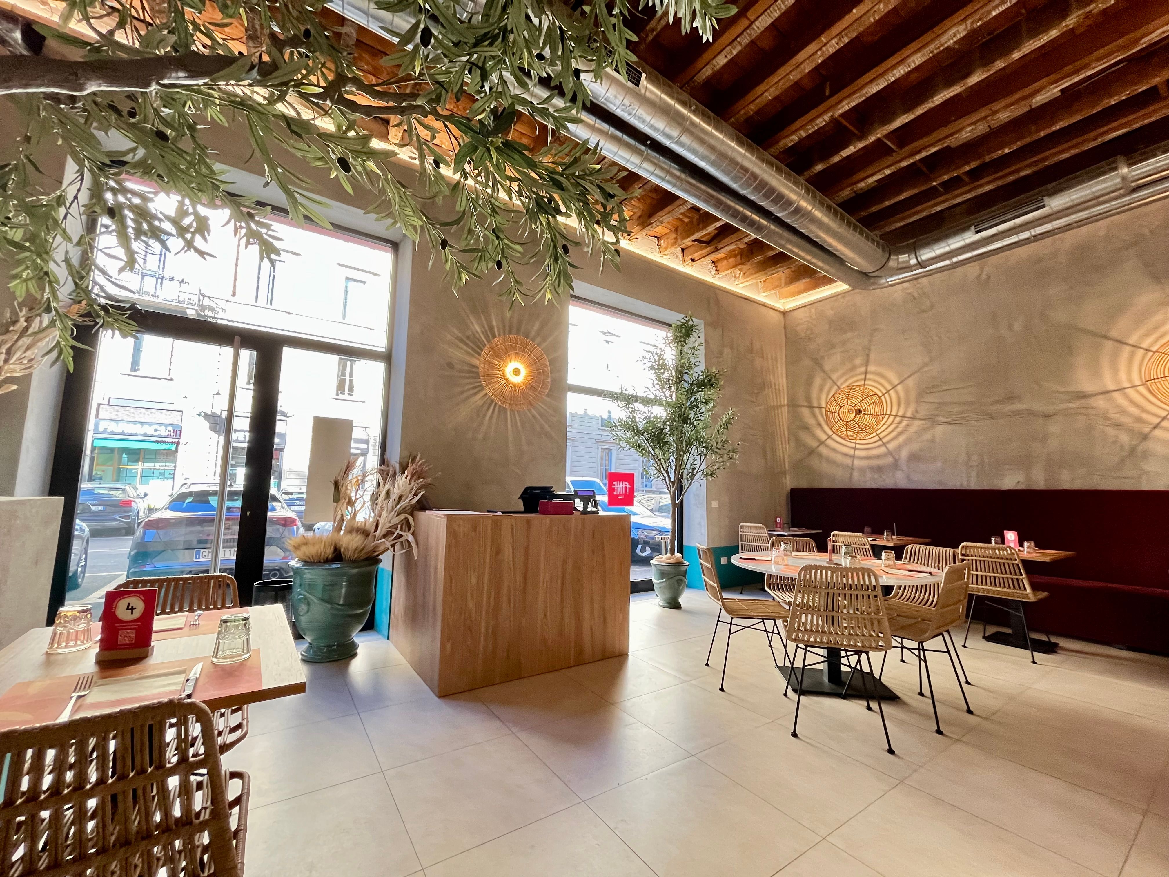 Two display windows, Entrance door, Tables and chairs, Cash counter, Wooden ceiling, Decorative plants