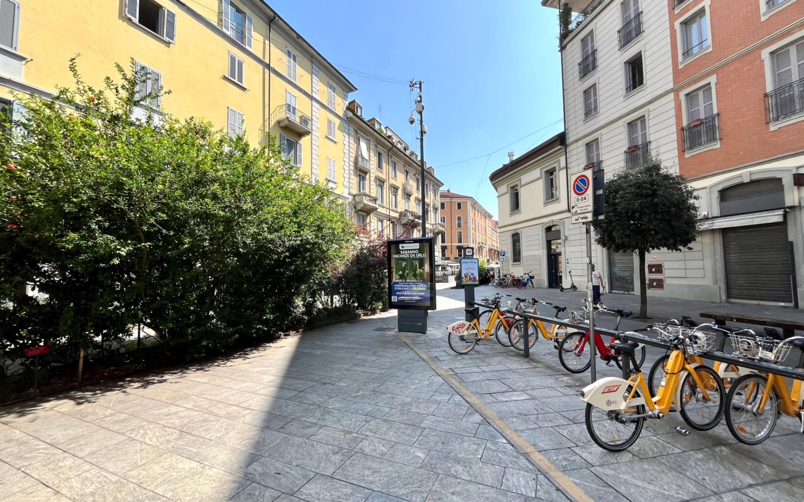 piazza, bicing, piante, palazzi con finestre e balconi, negozi