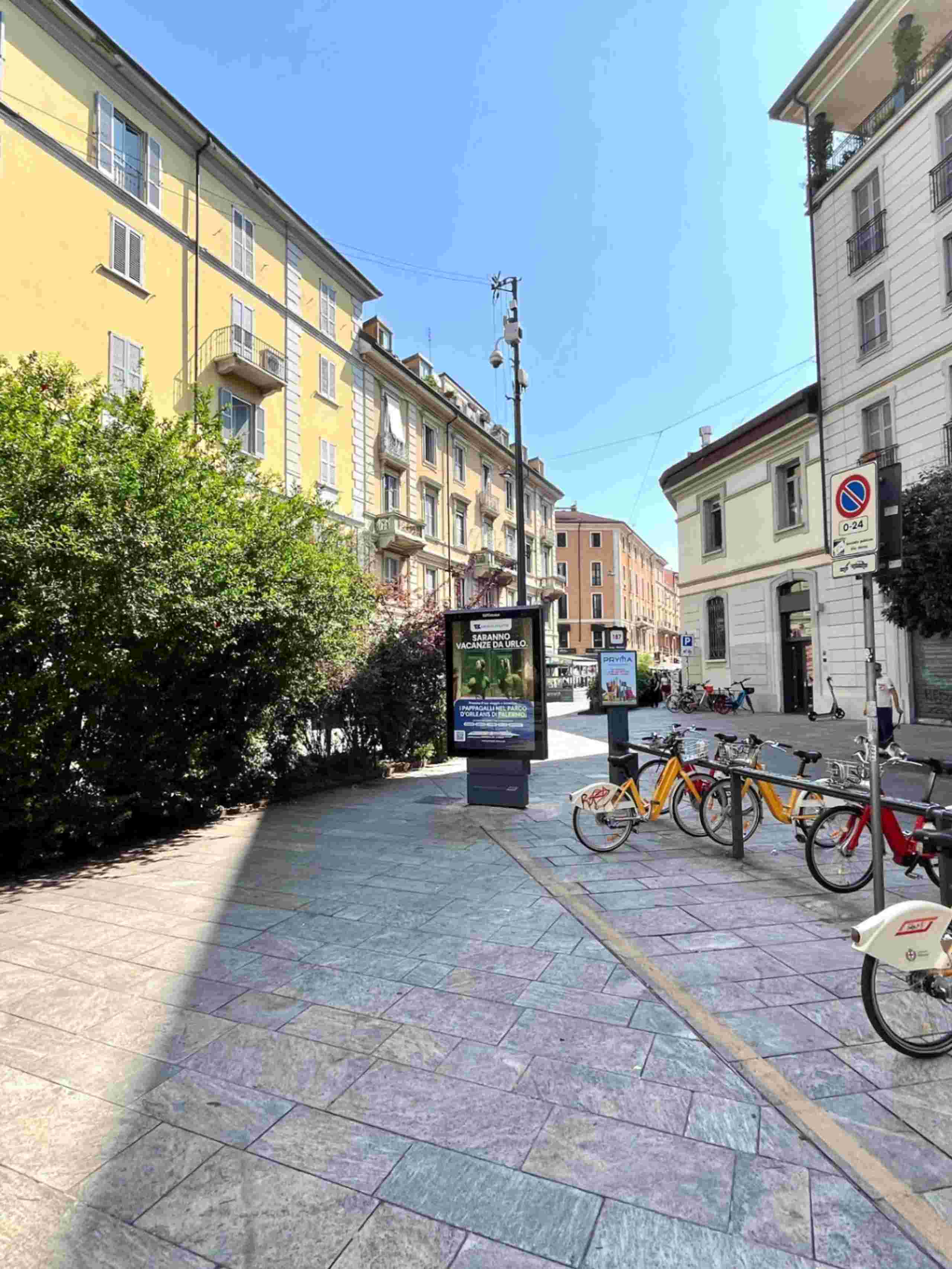 piazza, bicing, piante, palazzi con finestre e balconi, negozi