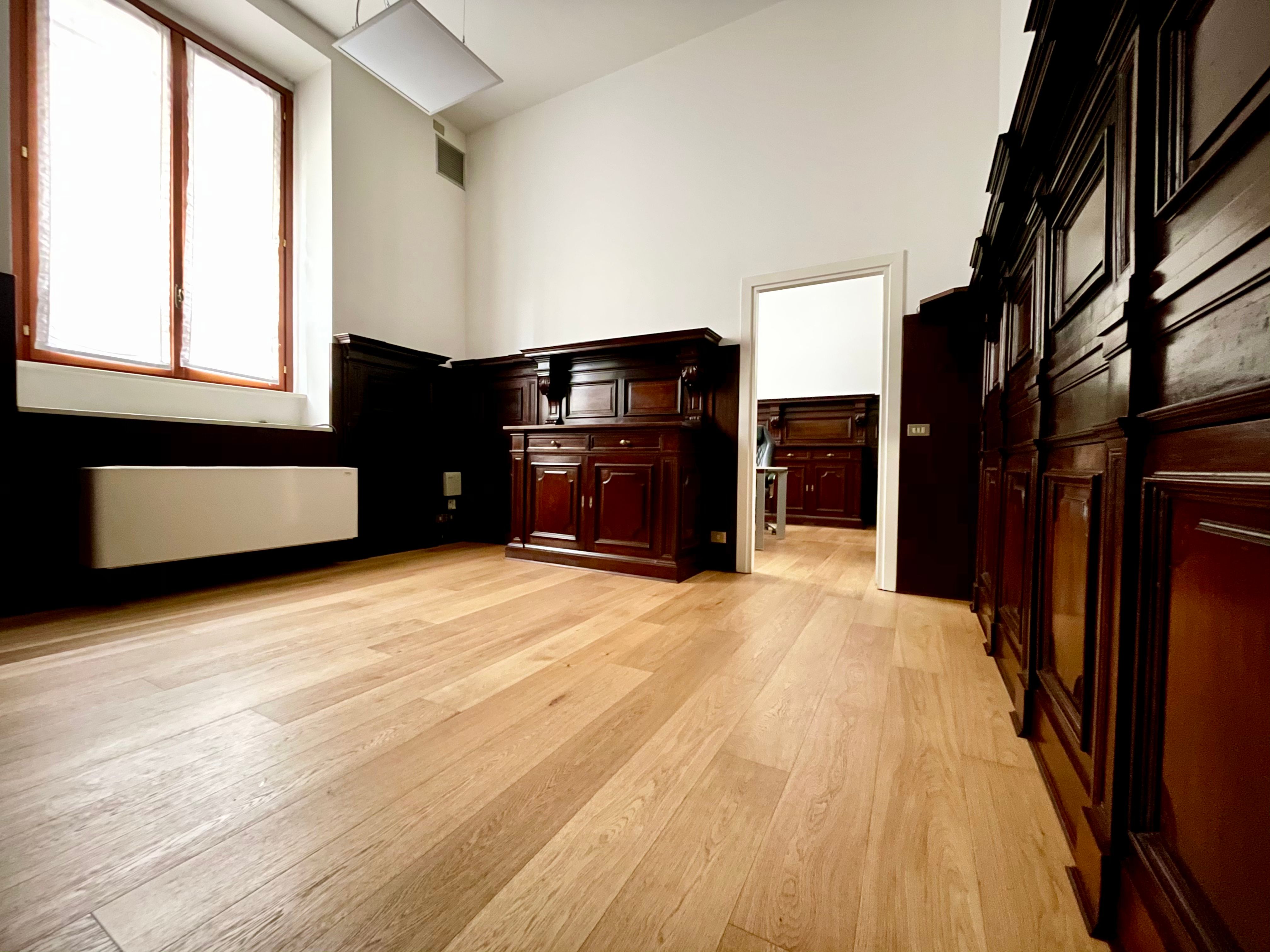 ufficio con parquet, pareti in legno scuro, finestra con tende