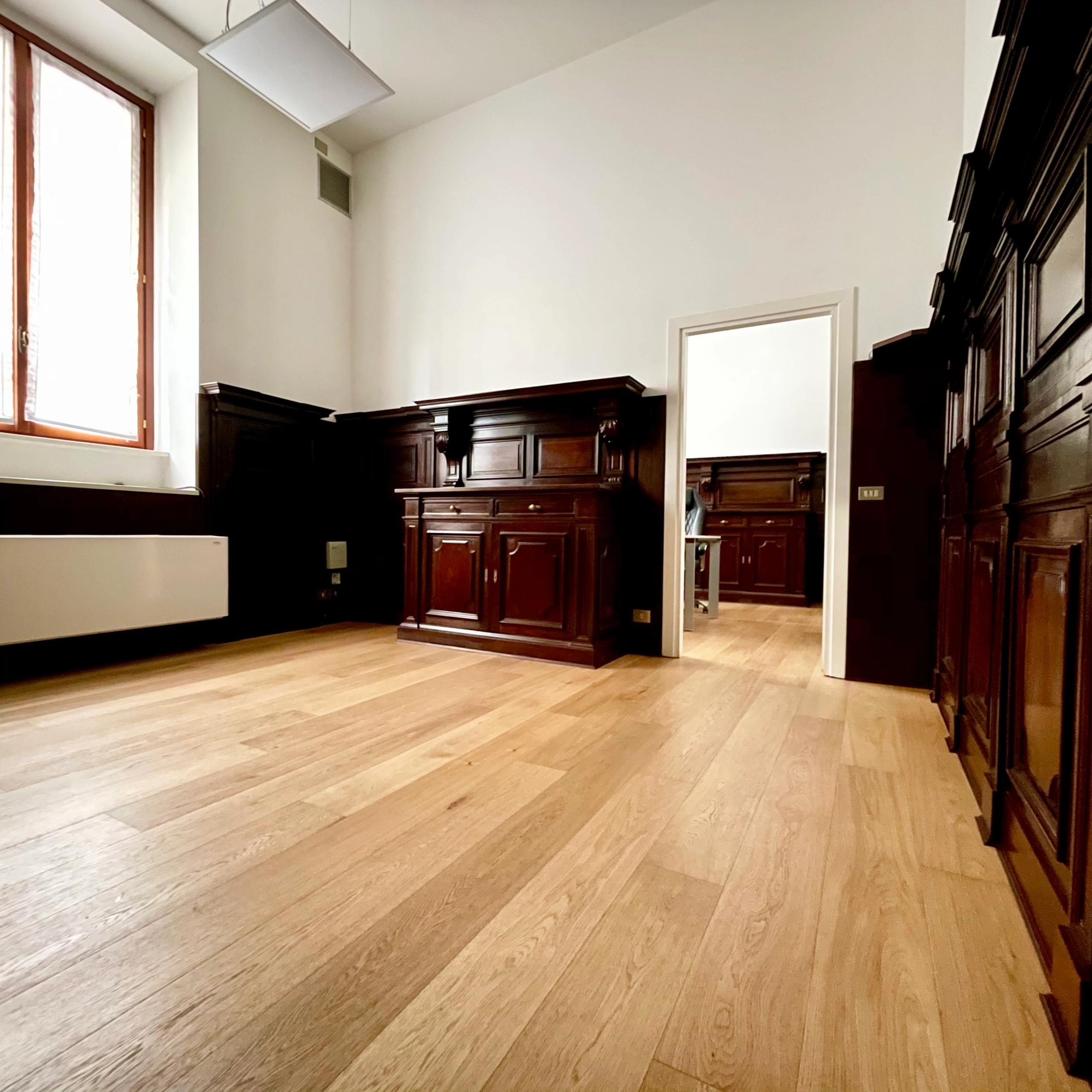 ufficio con parquet, pareti in legno scuro, finestra con tende