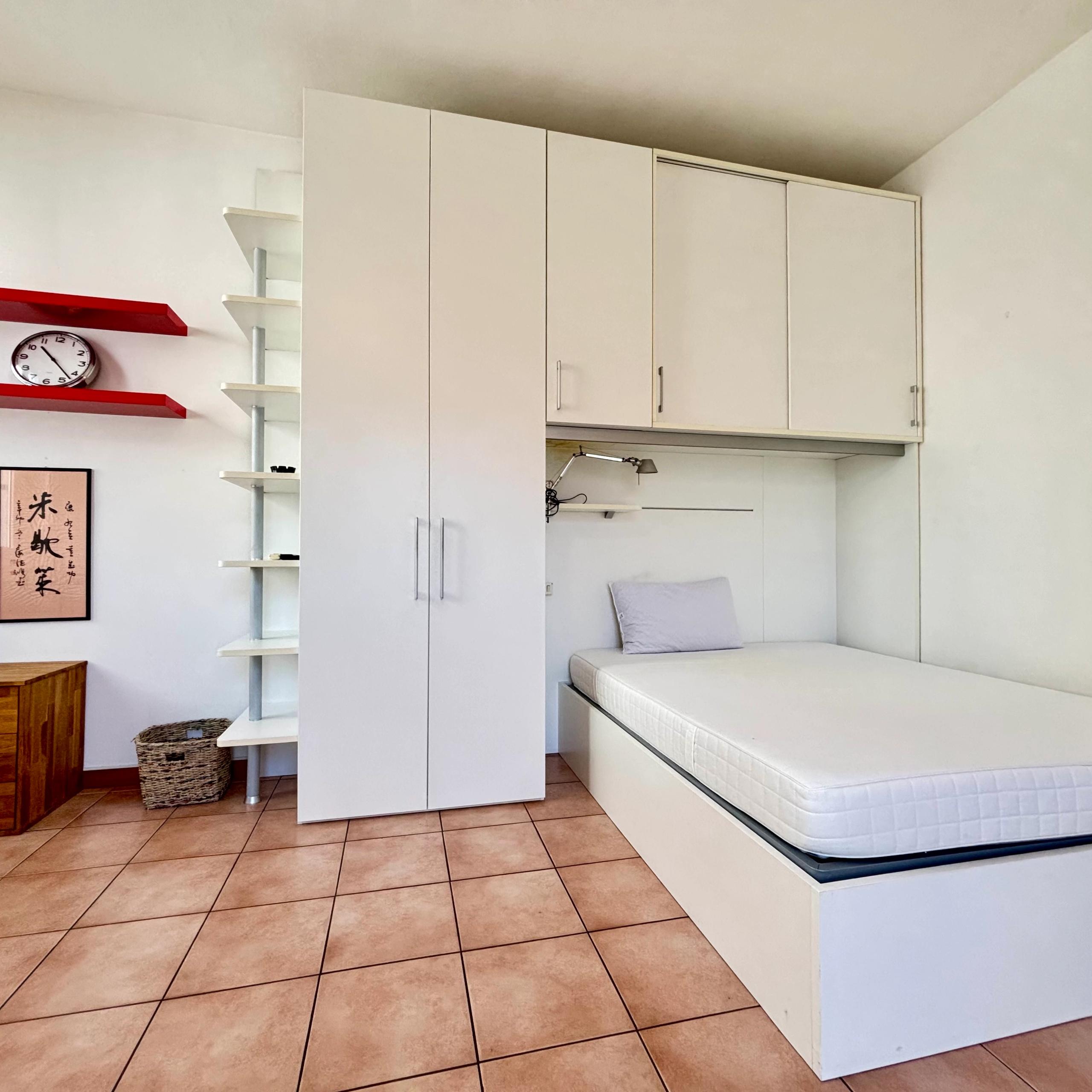 camera da letto, con armadio , libreria, mensole orologio codonino, cesto e quadro