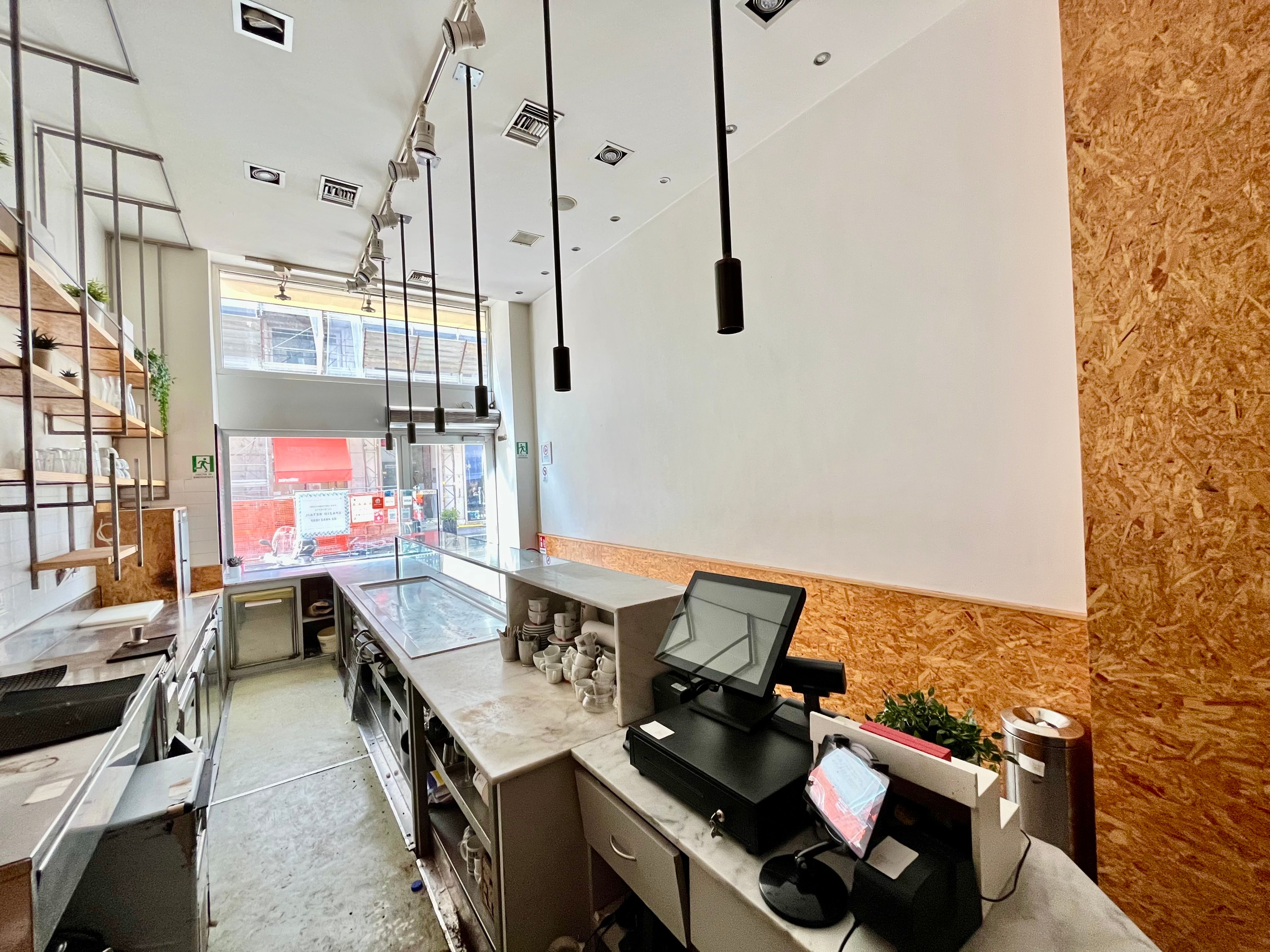 interno bar, con bancone, luci, vetrina su strada, libreria