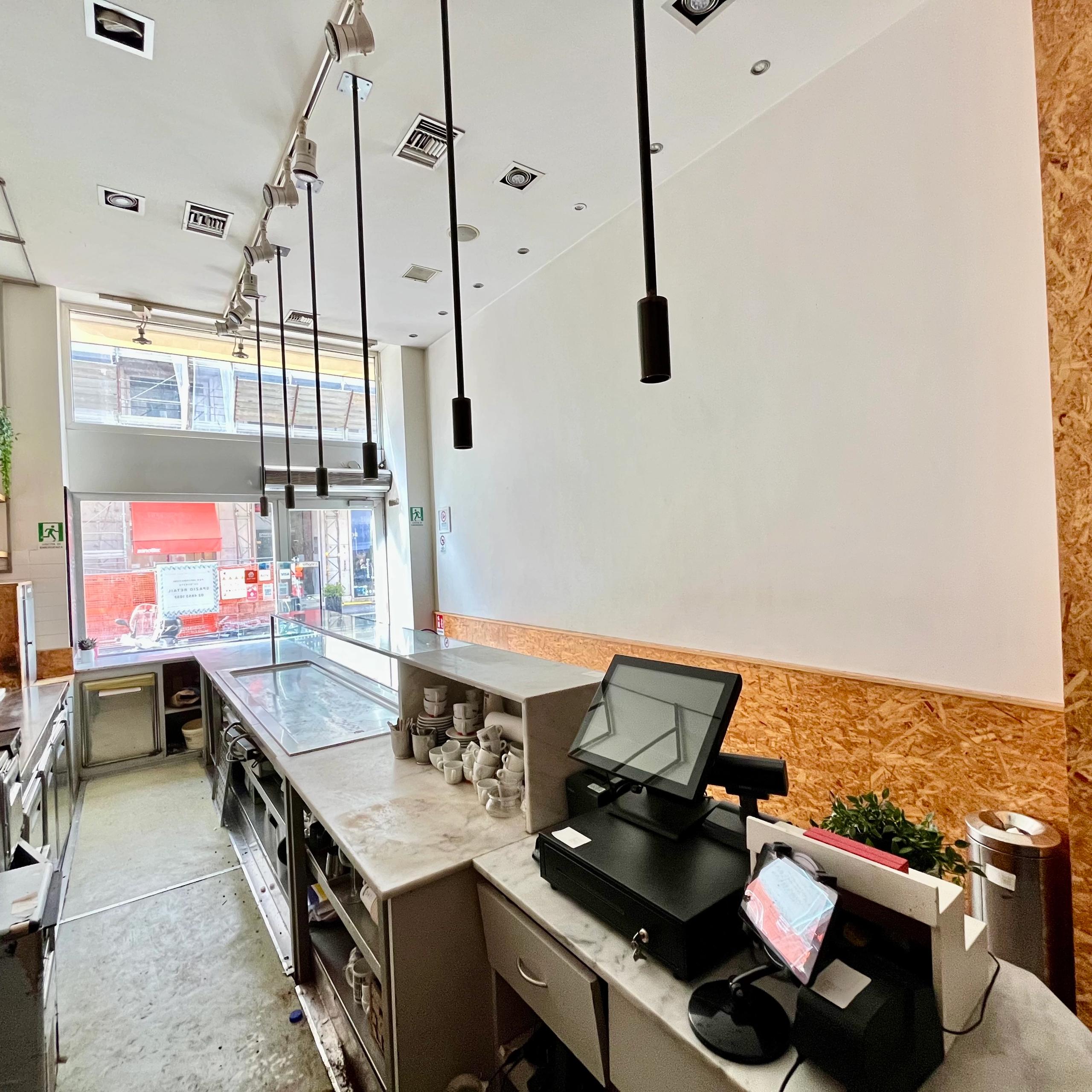 interno bar, con bancone, luci, vetrina su strada, libreria