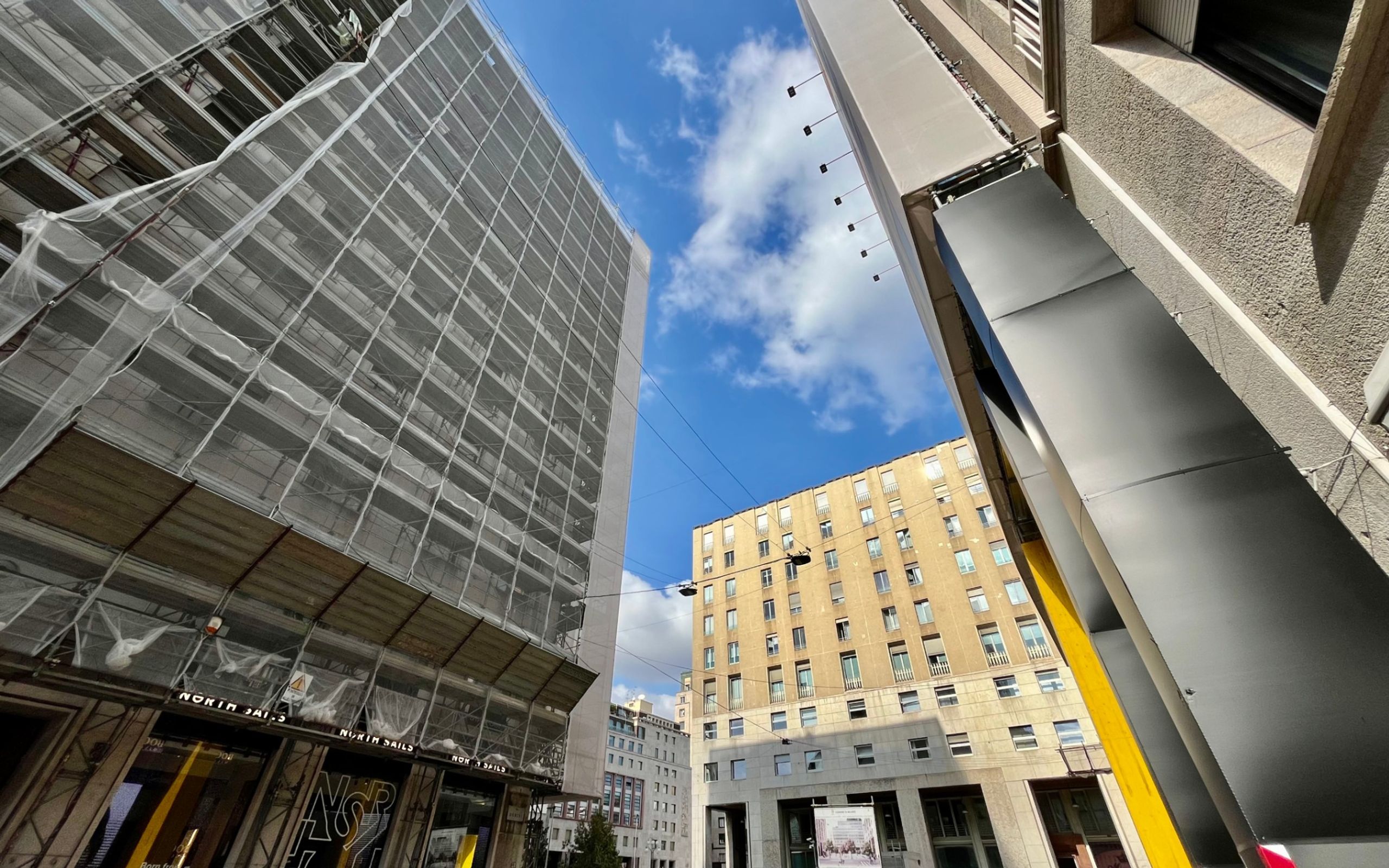 Milano via Durini, edifici con finestre, impalcatura, cielo