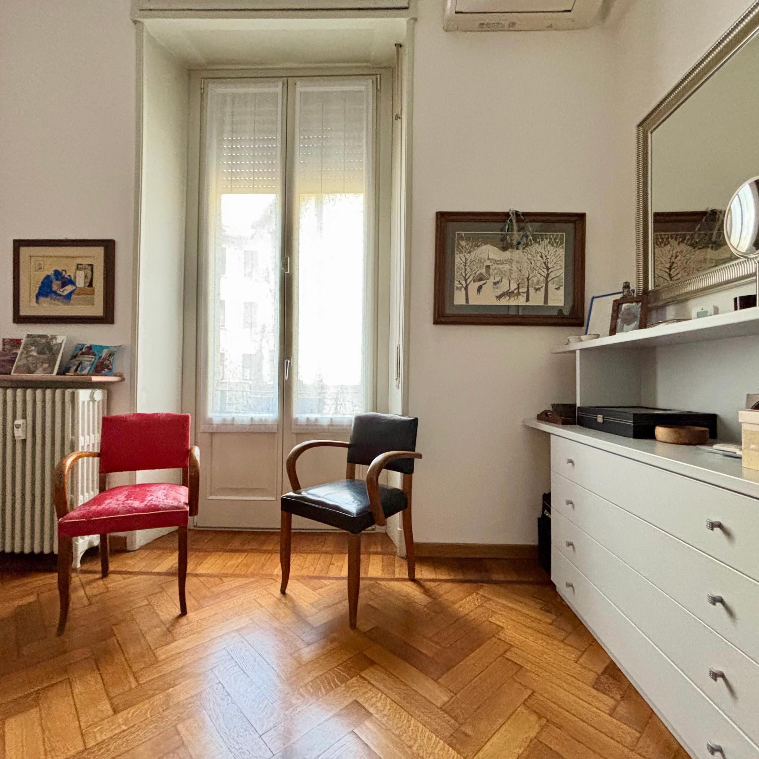 room with window, mirror, two chairs, chest of drawers, heaters