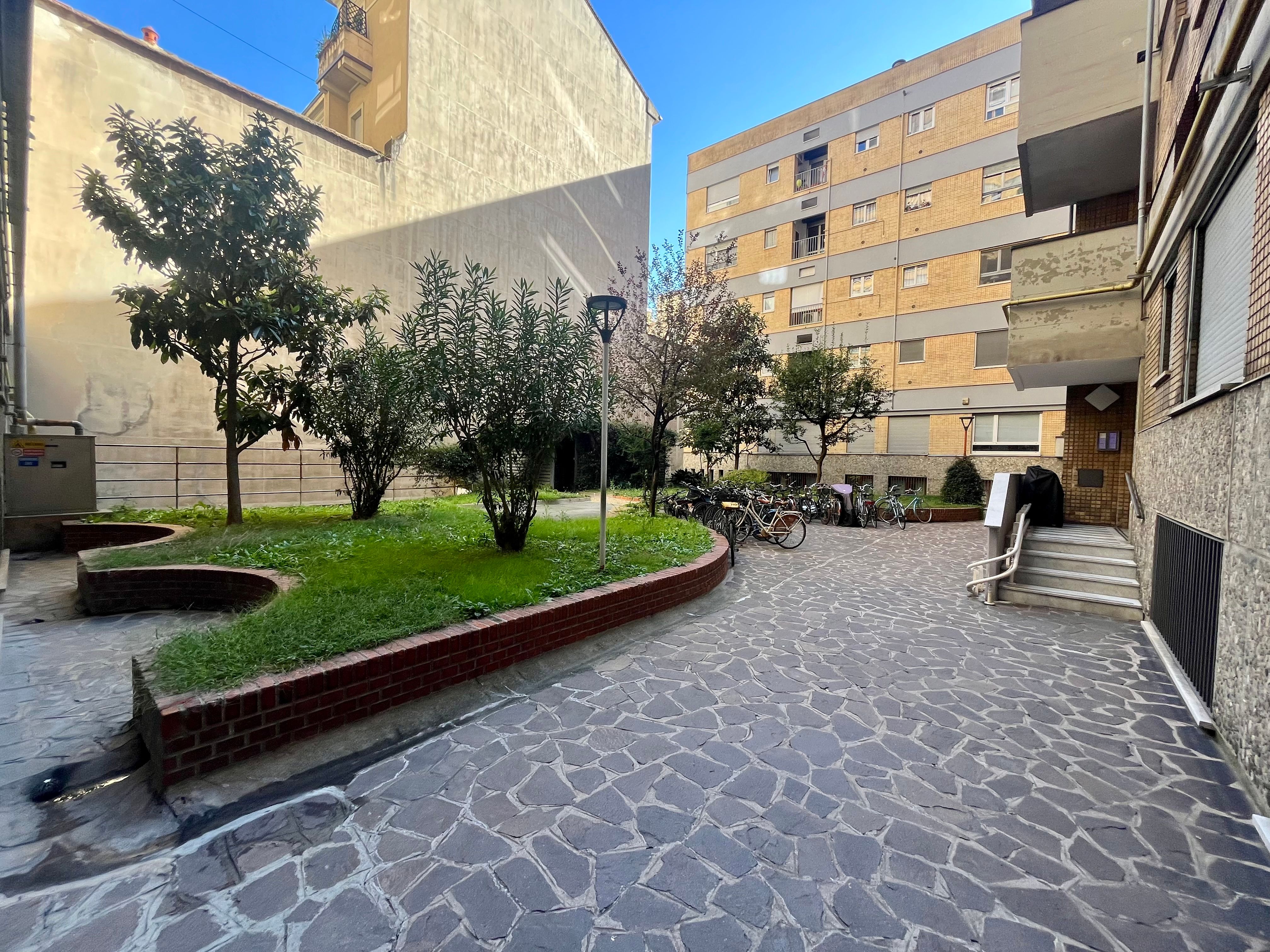 cortile interno, erba, palazzi, finestre, scale, alberi