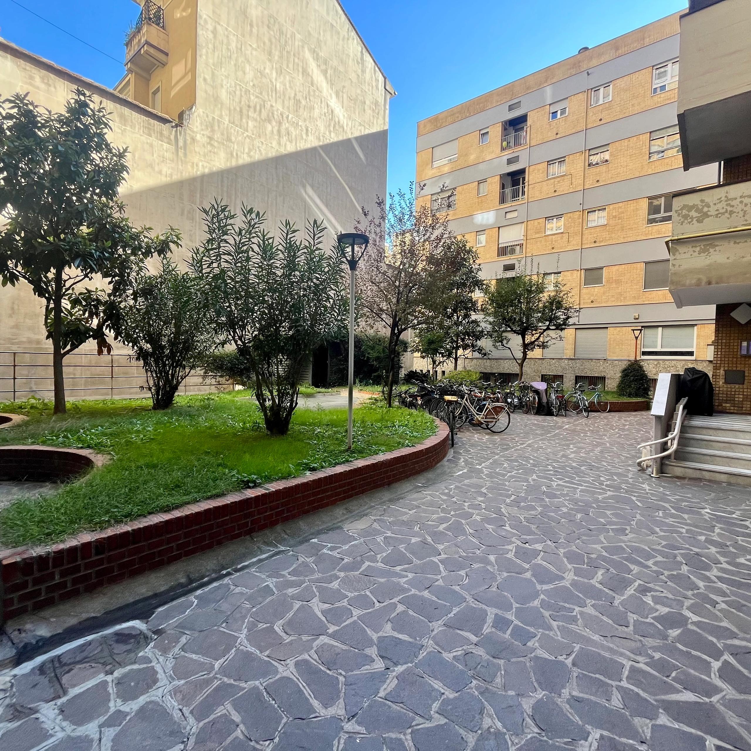 cortile interno, erba, palazzi, finestre, scale, alberi
