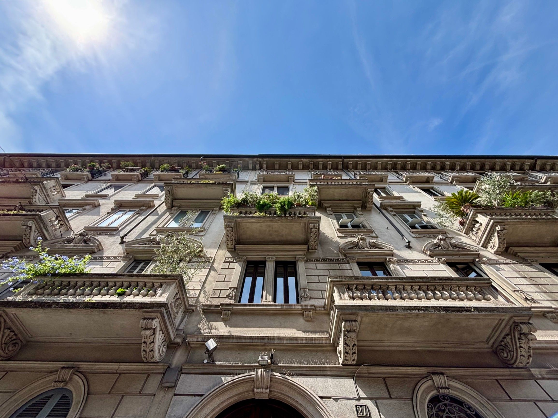 Building with windows balconies and plants