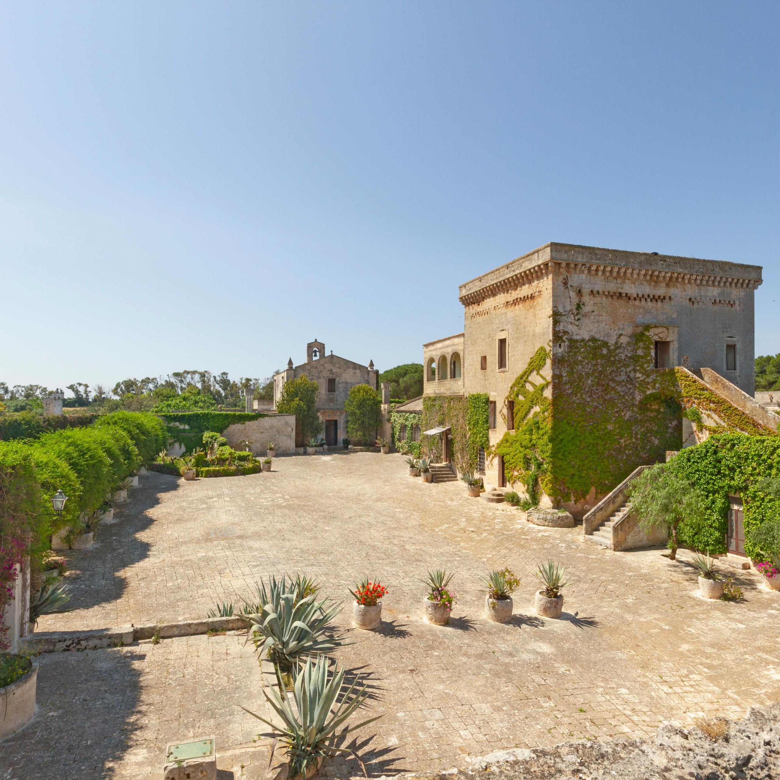 grande patio interno alla masseria, chiesa consacrata e torre saracena, scalini, cielo